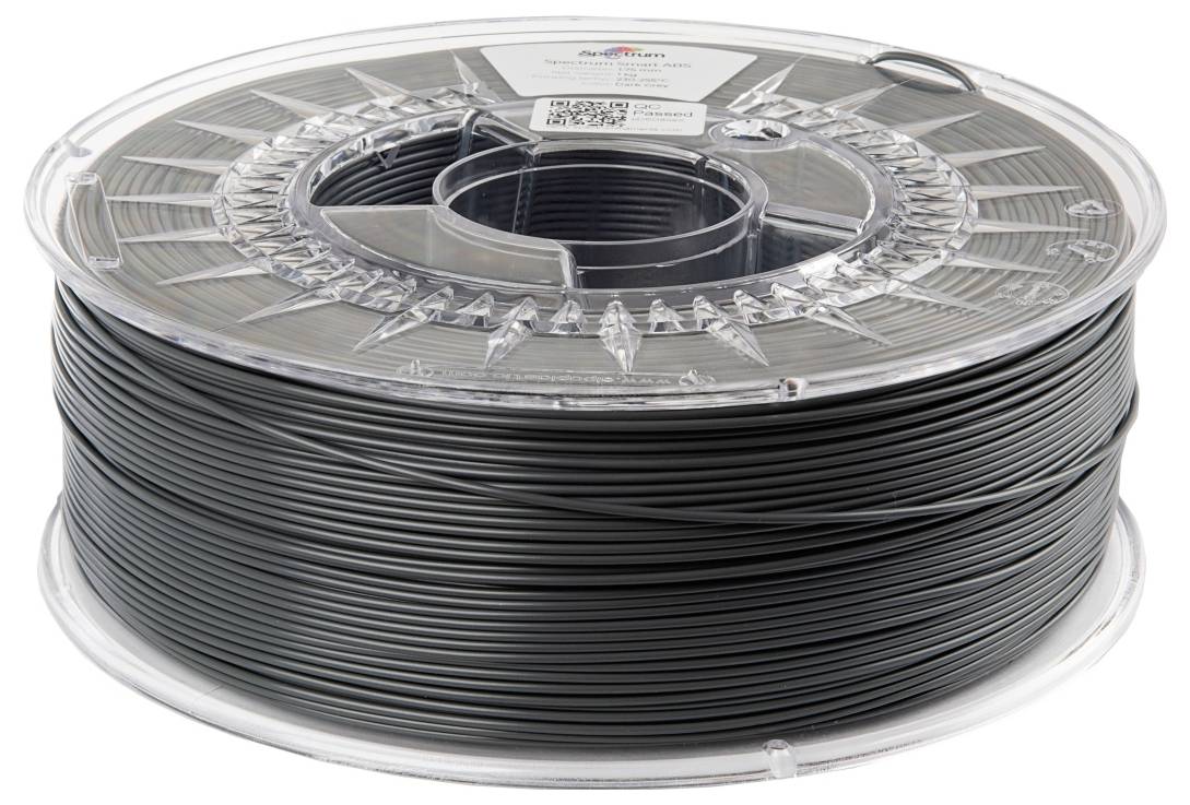 Een transparante spoel met zwart 3D-printerfilament, liggend op een schoon, wit oppervlak.