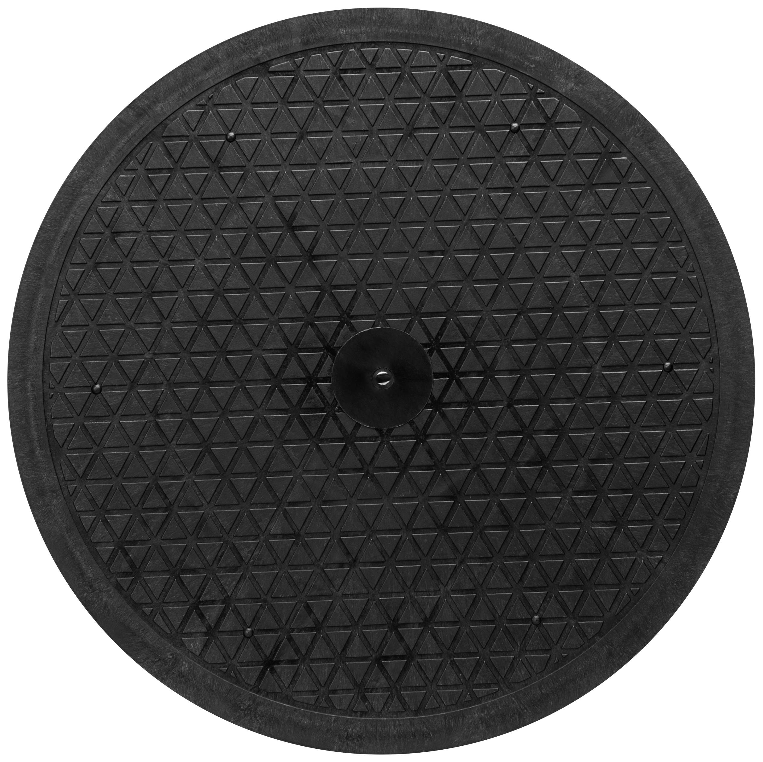 Een zwart, rond balancebord met een slipvaste oppervlakte en een driehoekig patroon.