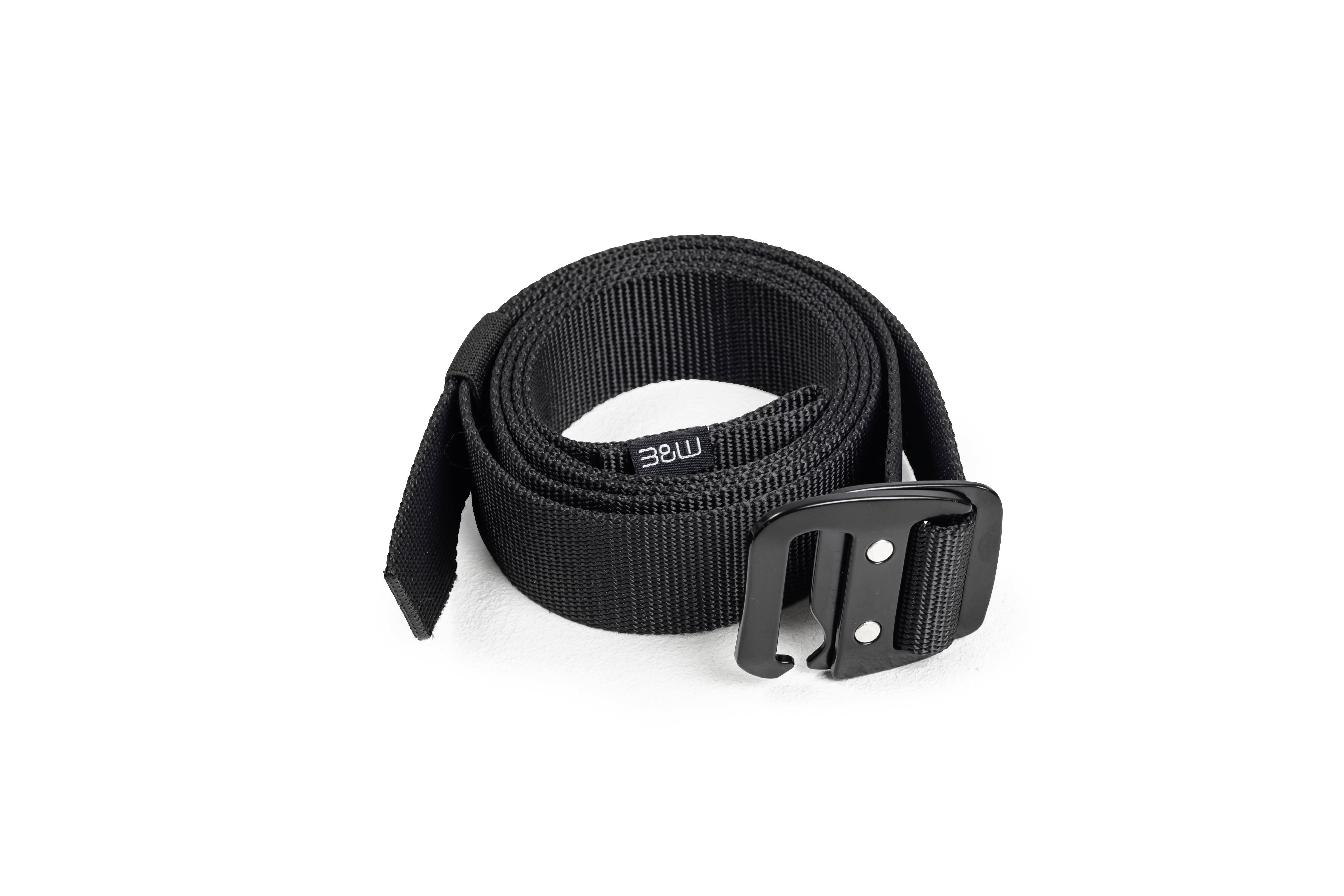 Een opgerolde zwarte riem met een metalen gesp ligt op een wit oppervlak.