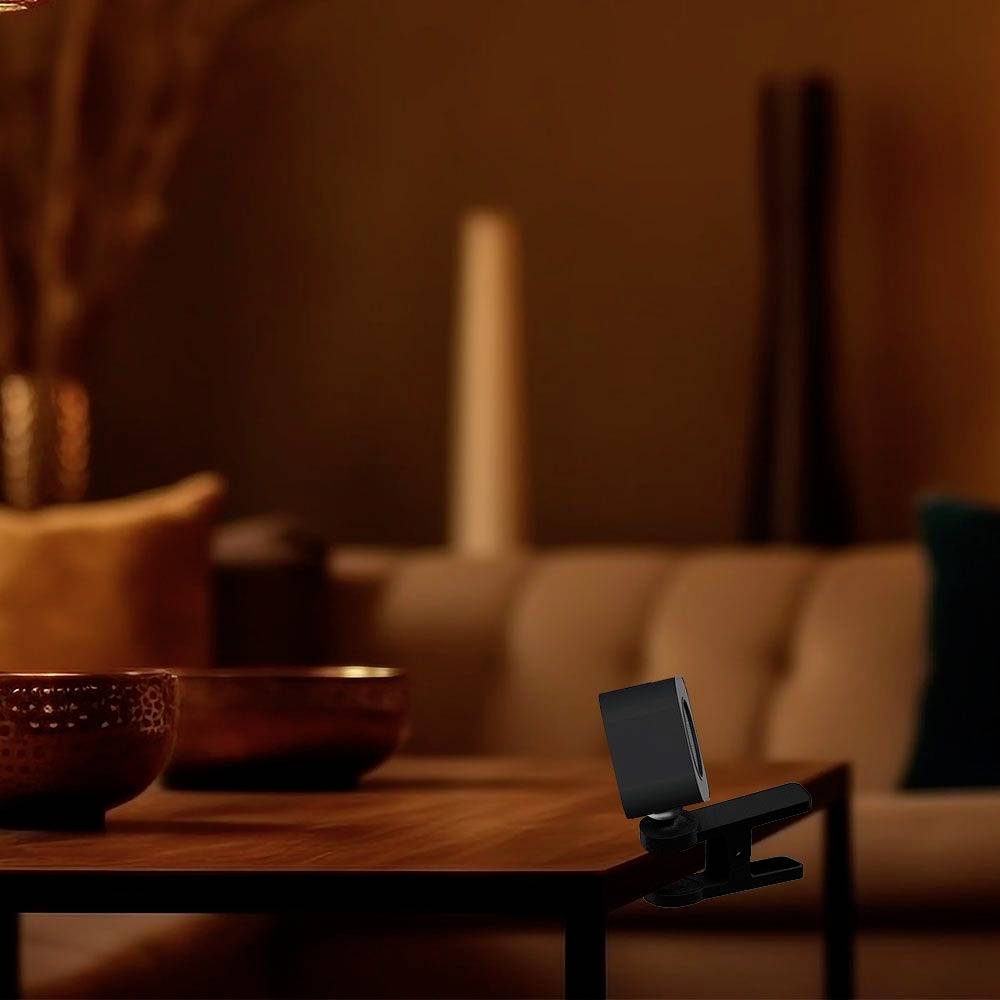 Een elegante ruimte met een houten tafel, waarop keramische schalen staan en op de achtergrond een gezellige bank-indeling.