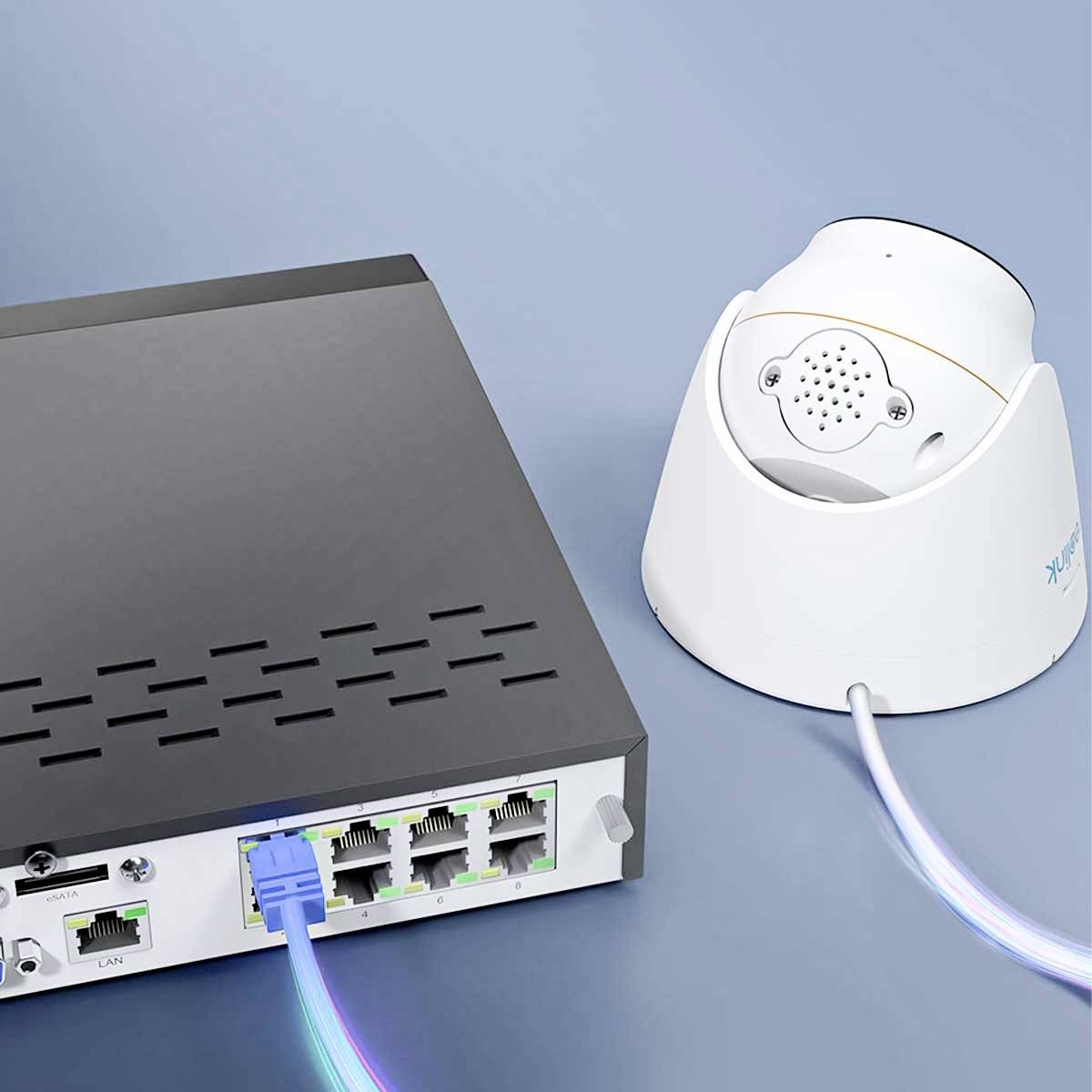 Een netwerk-switch met meerdere Ethernet-poorten is verbonden met een witte beveiligingscamera-dome.