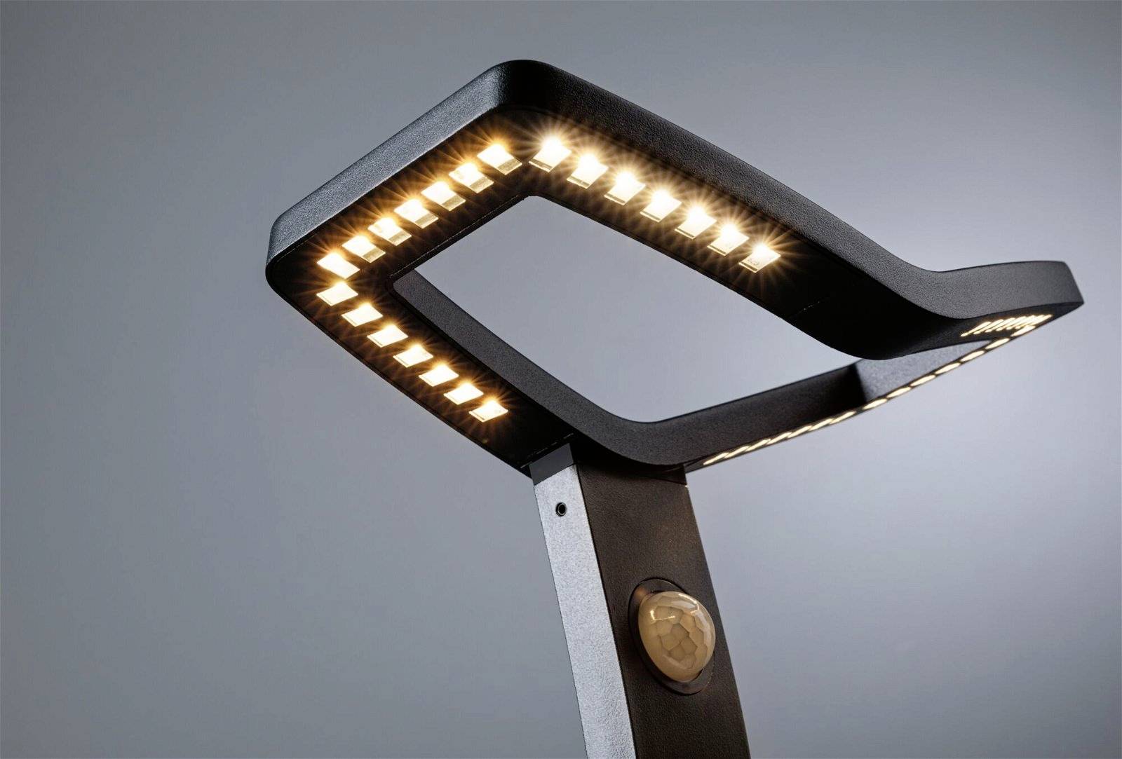 Een moderne LED-straatlantaarn met een rechthoekig, hoekig ontwerp. De armatuur straalt helder, warm wit licht uit.