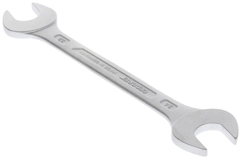 Een zilveren steeksleutel met twee bekken, aan de ene kant 22 mm en aan de andere kant 24 mm, ligt op een witte ondergrond.