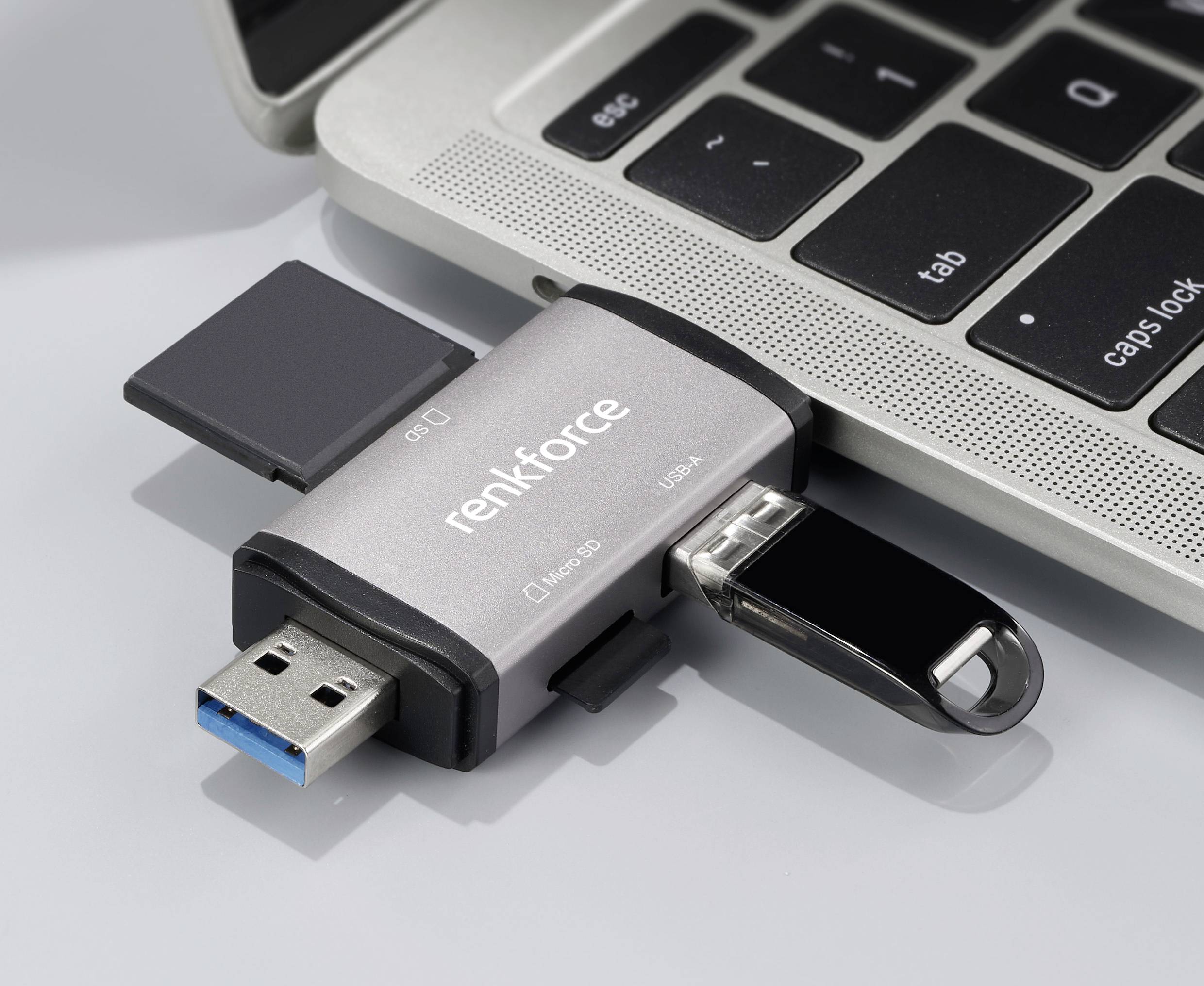 Een USB-stick met 'Renkforce'-logo is aangesloten op een laptop. De stick heeft verschillende aansluitingen en poorten.