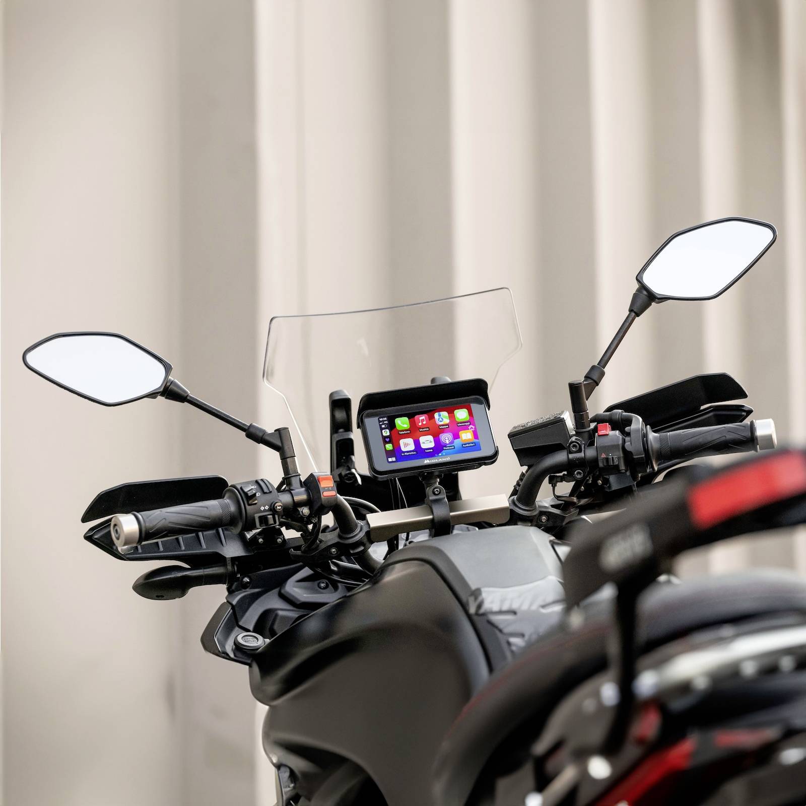 Een motorrijder met een ingebouwd GPS-navigatieapparaat dat een kleurrijke kaart weergeeft. De achteruitspiegels zijn zichtbaar.