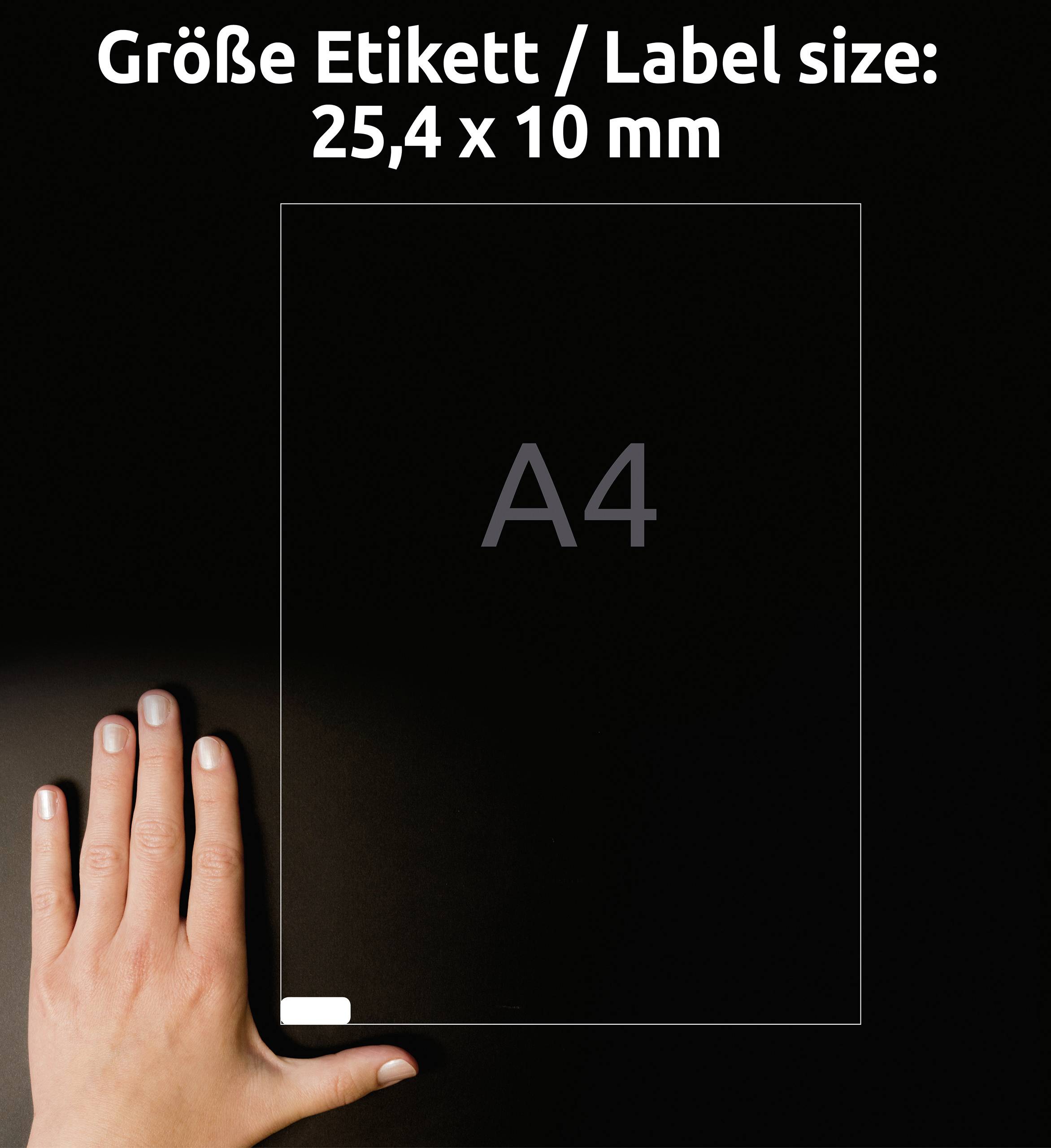 'Grootte etiket / Labelmaat: 25,4 x 10 mm' in witte tekst op zwarte achtergrond. Een hand ligt naast een A4-blad ter groottebepaling.