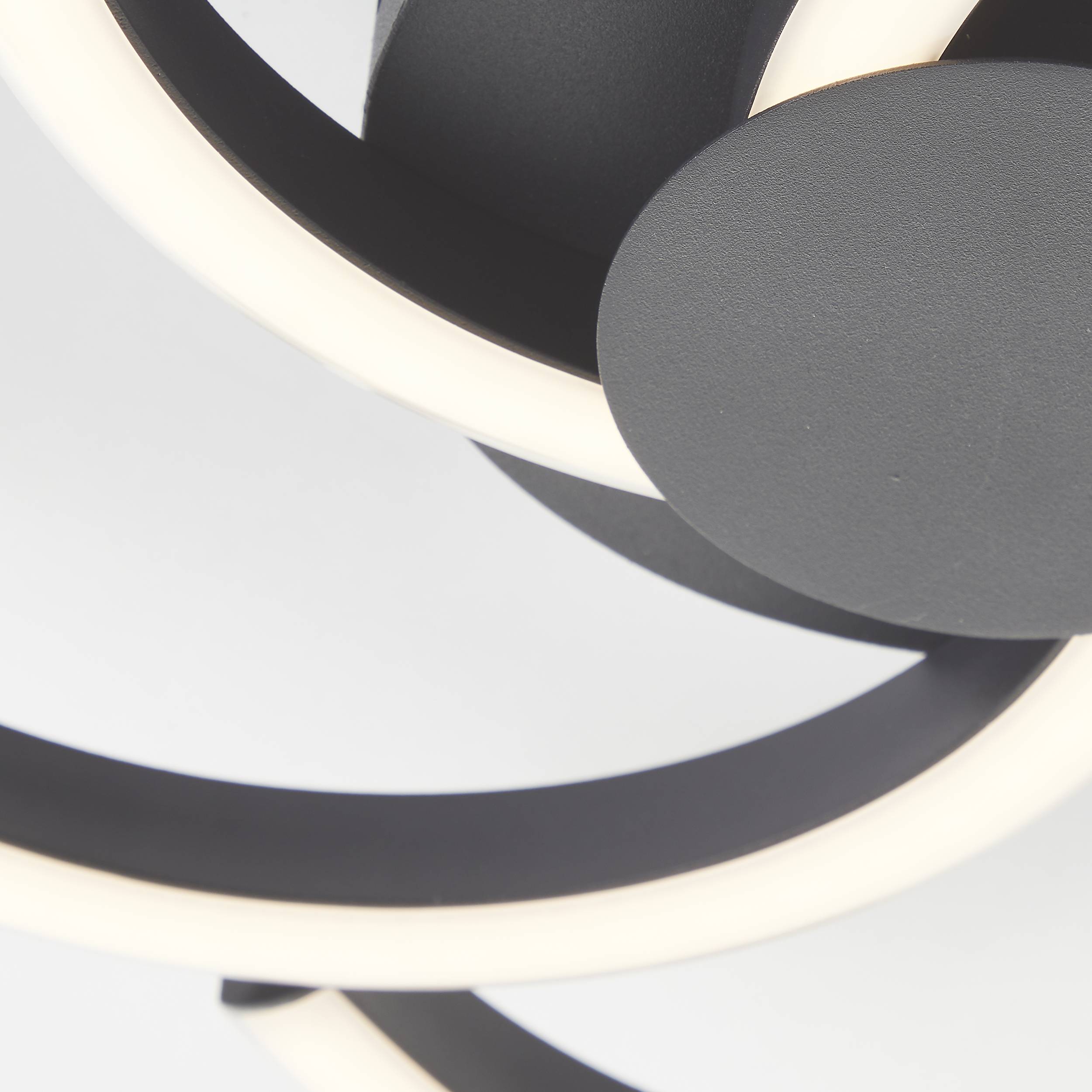 Abstracte, spiraalvormige lampen met zwart en stralend wit ontwerp tegen een neutrale achtergrond; modern verlichtingselement.