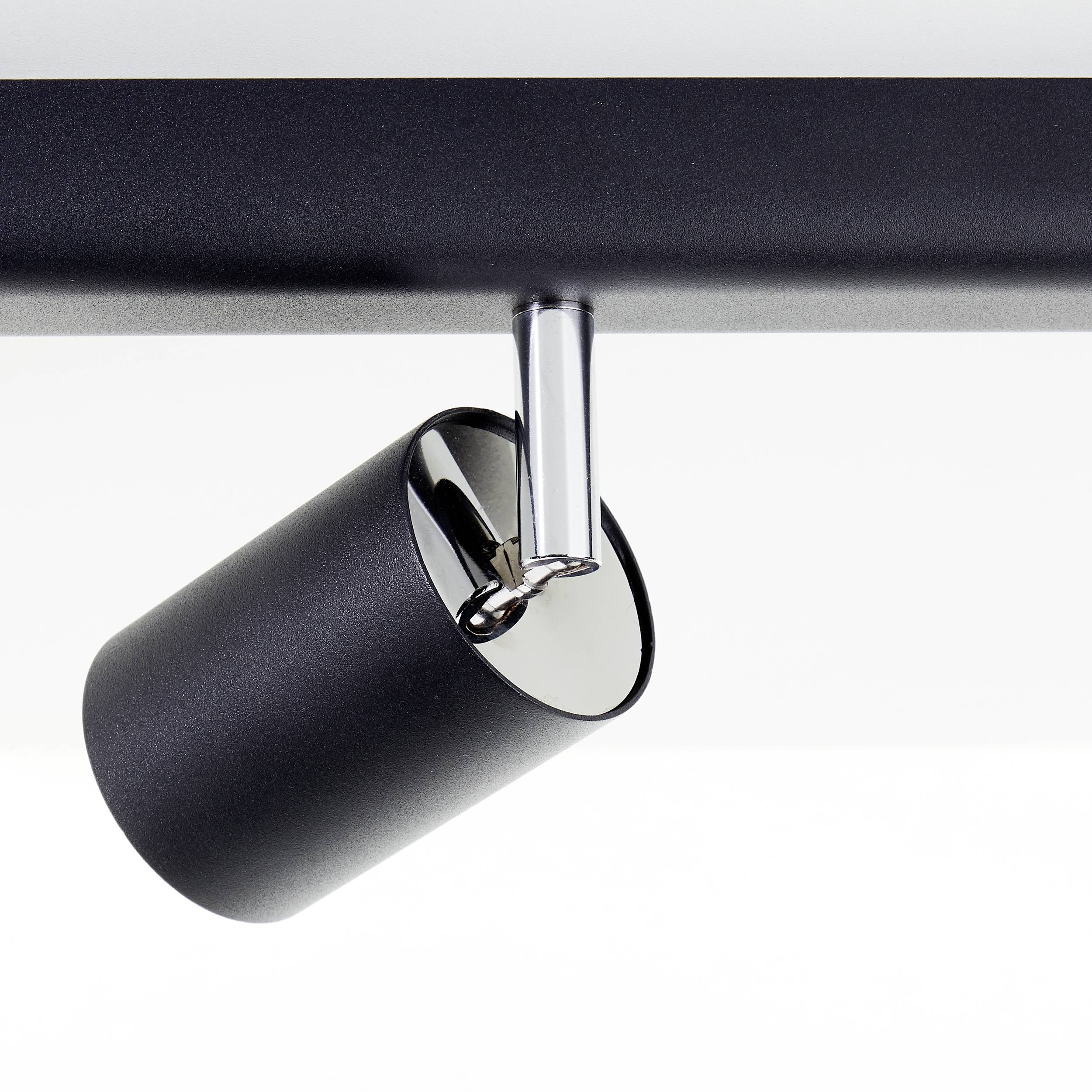 Een moderne zwarte plafondlamp met een verstelbare cilindrische lampenkop, bevestigd aan een slanke metalen stang.