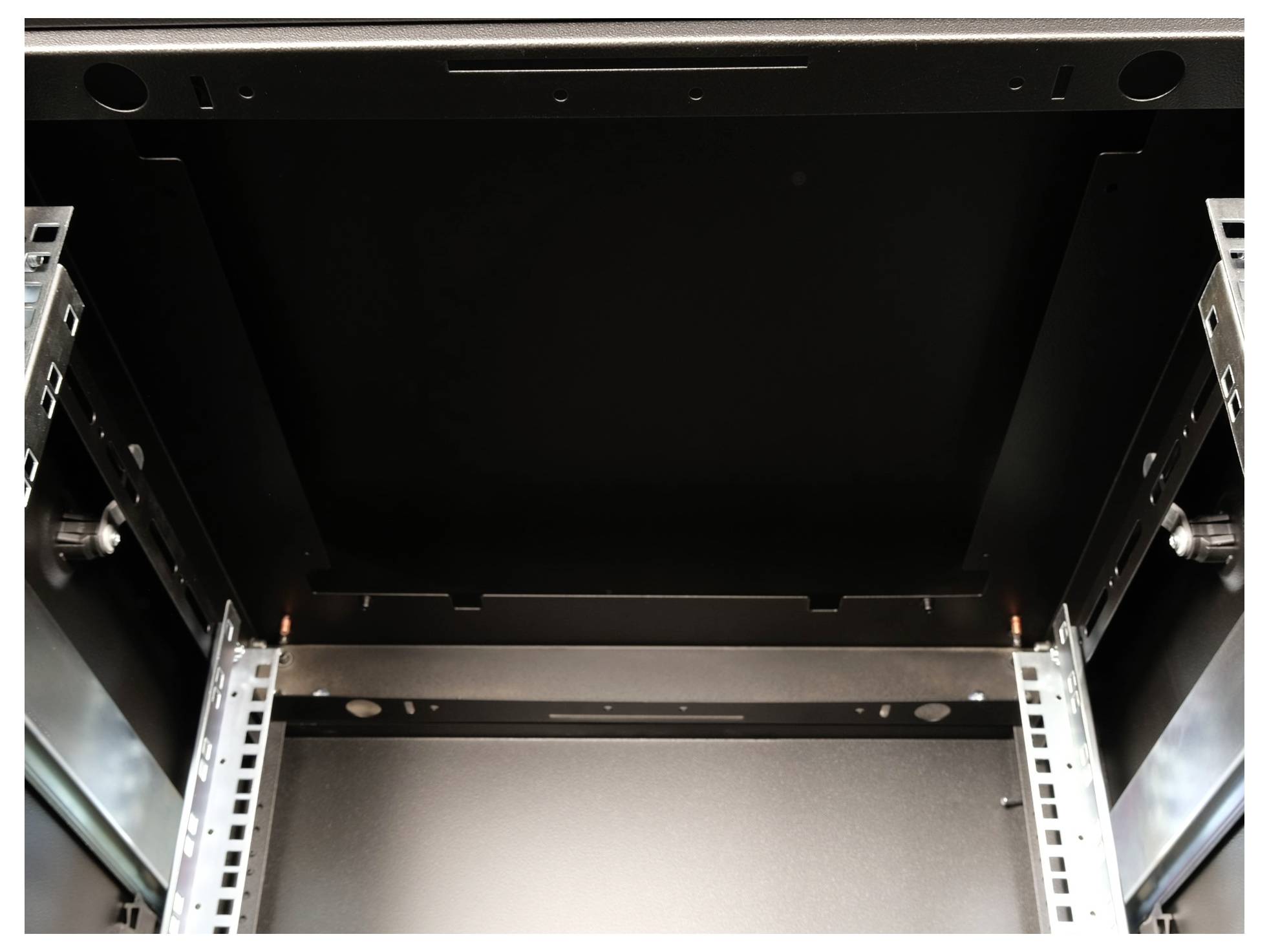 Binnenaanzicht van een leeg zwart serverrek met metalen frame en geleiders aan de zijkanten.