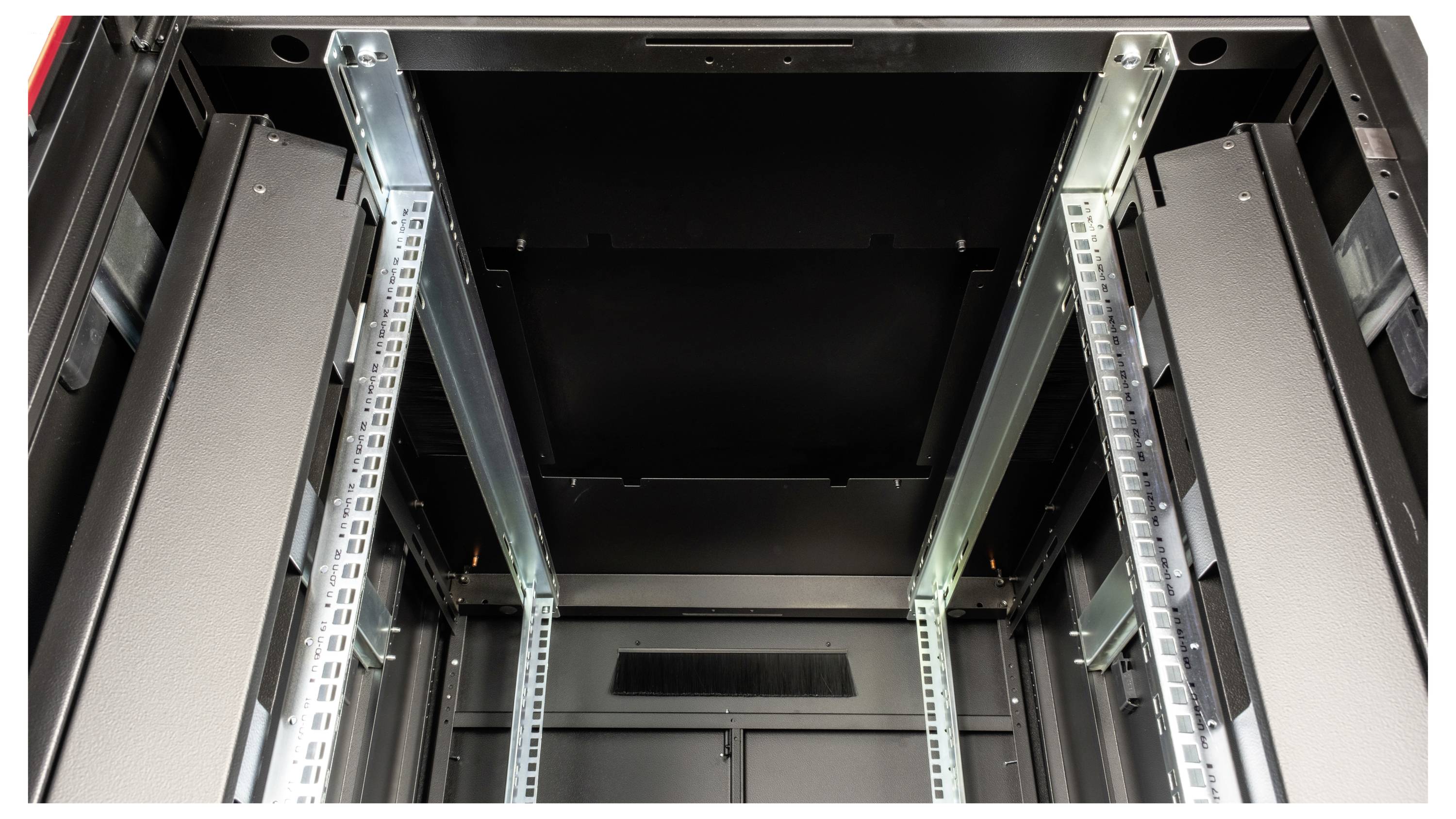 Binnenaanzicht van een leeg serverrek met metalen steunen en zwarte wanden, klaar voor de installatie van IT-apparatuur.