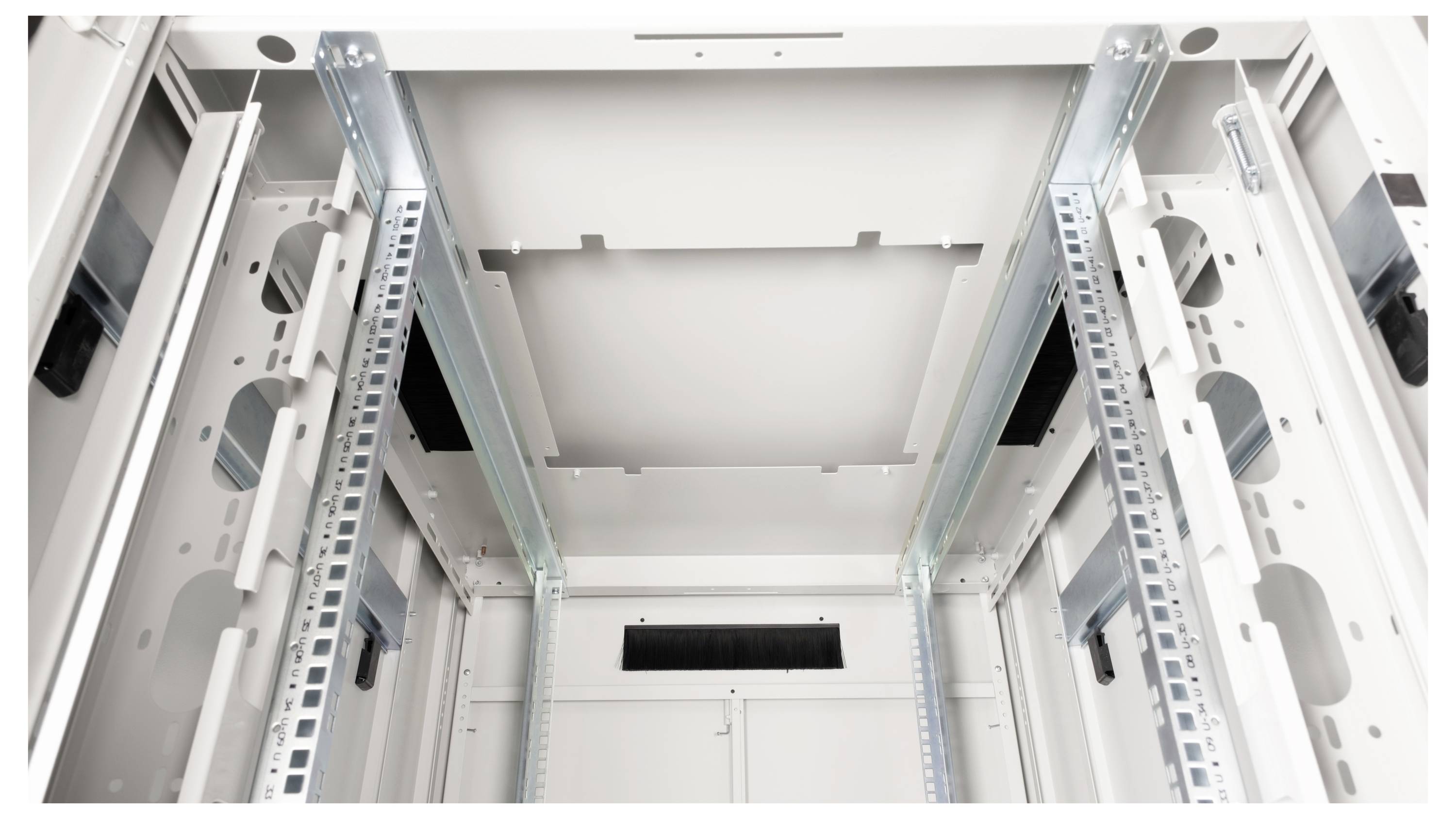 Binnenaanzicht van een leeg, grijs serverrek met metalen rails en kabelgoten, klaar voor de installatie van elektronische apparatuur.