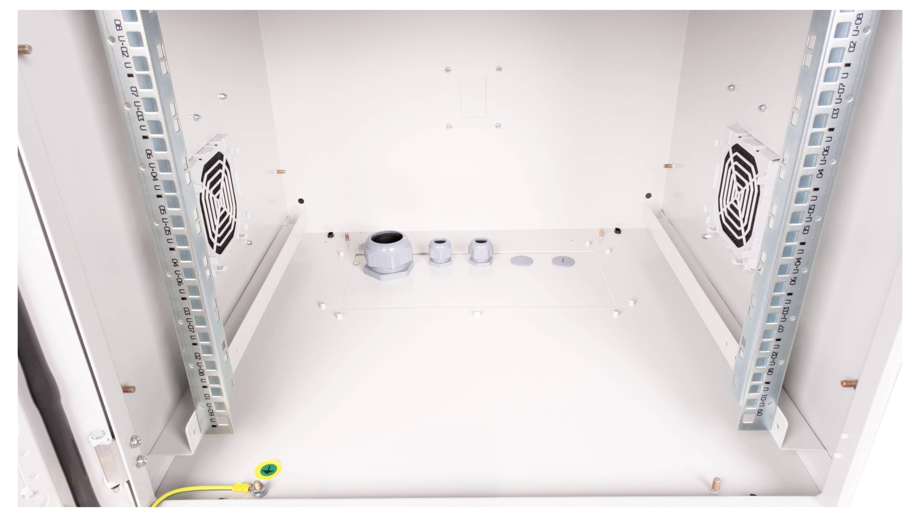 Binnenaanzicht van een lege metalen kast met ventilatiesleuven en kabelinvoergaten, klaar voor technische installaties.