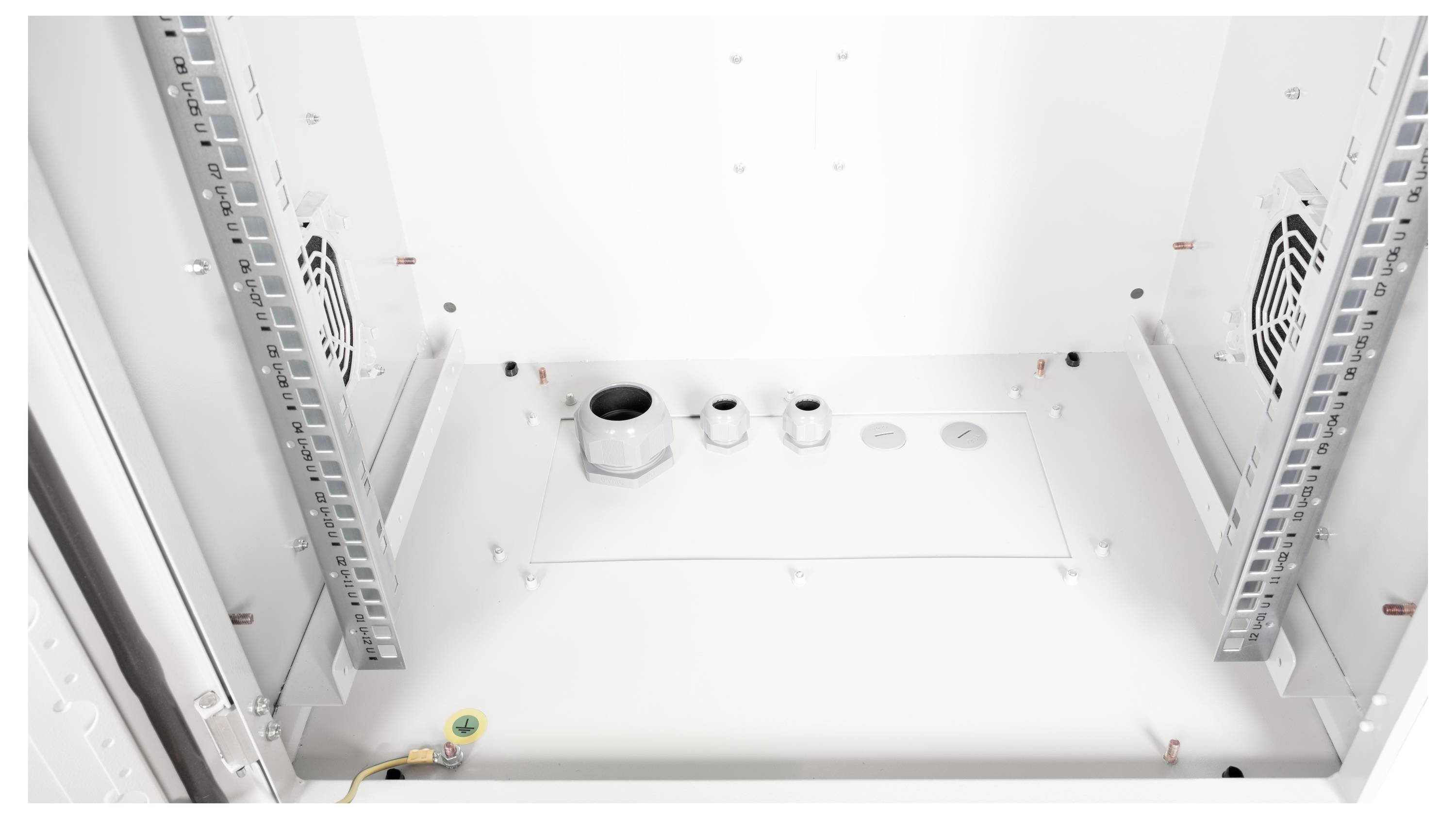 Blik in een lege kast met ventilatoren en kabelopeningen, klaar voor de installatie van elektronische apparaten.