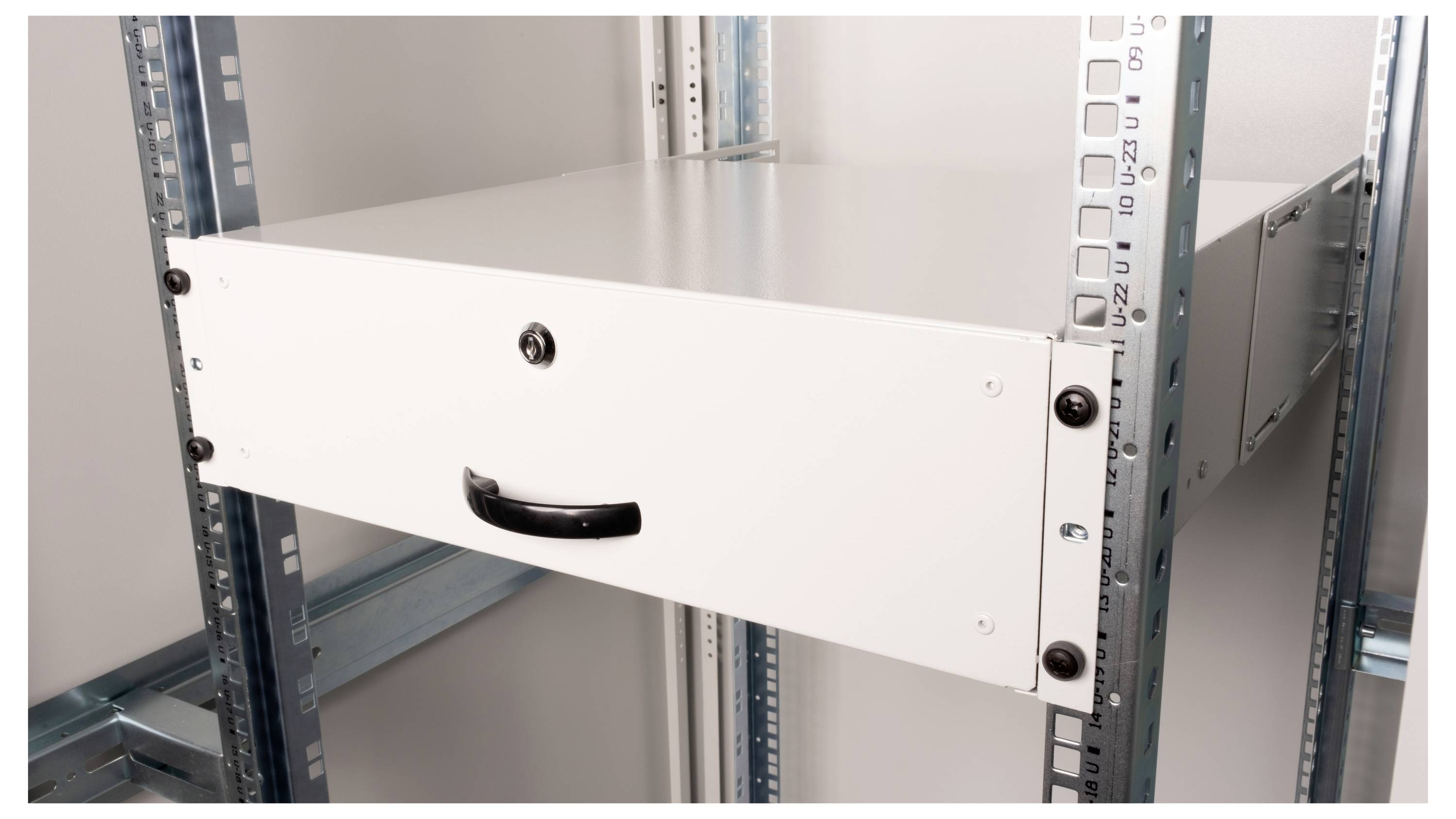 Een wit metalen rek met een lade in een open serverrek. De lade heeft een zwarte handgreep en is gesloten.