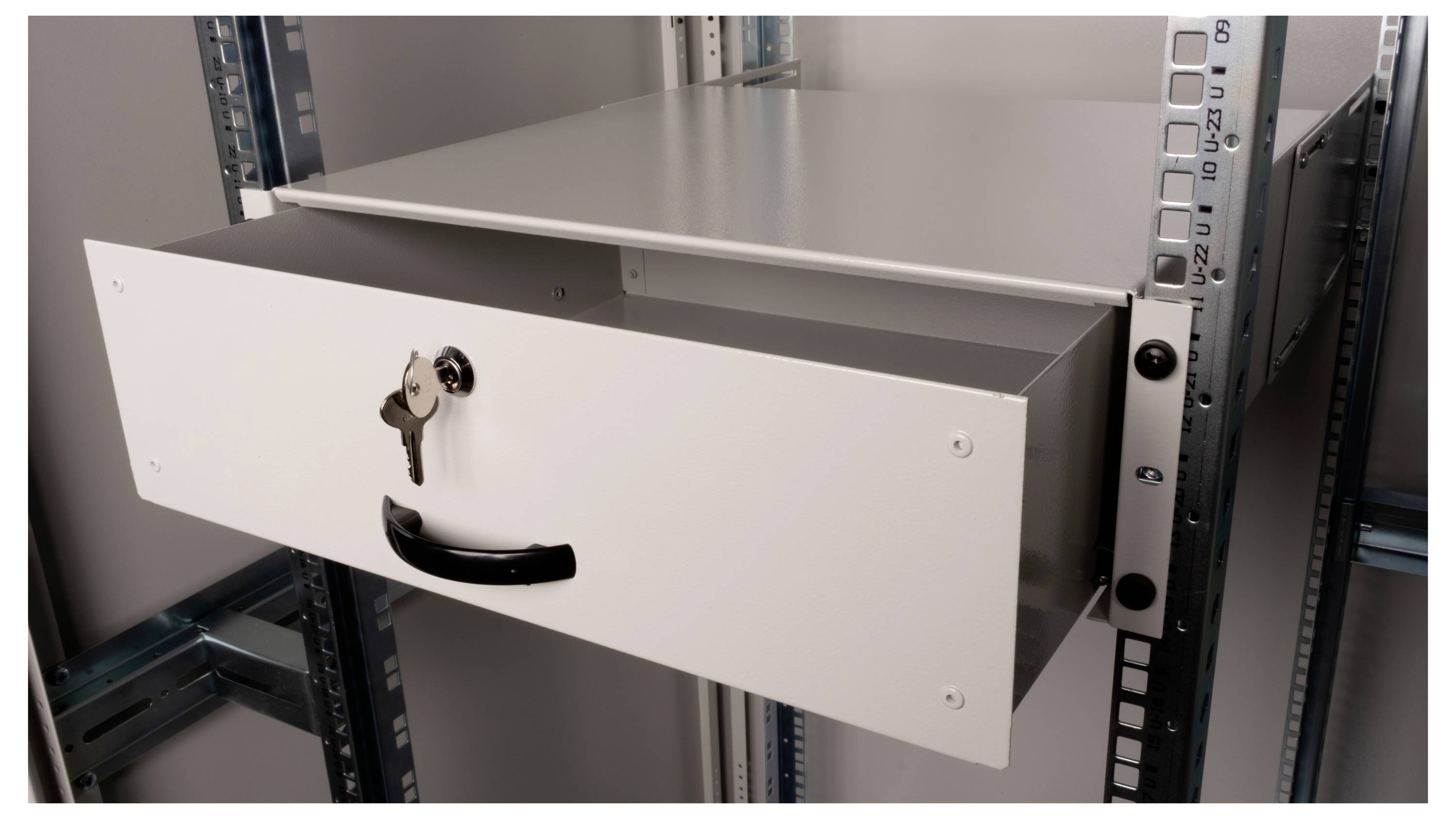 Een witte lade met een zwarte greep staat half open. Een sleutel steekt in het slot van de lade.