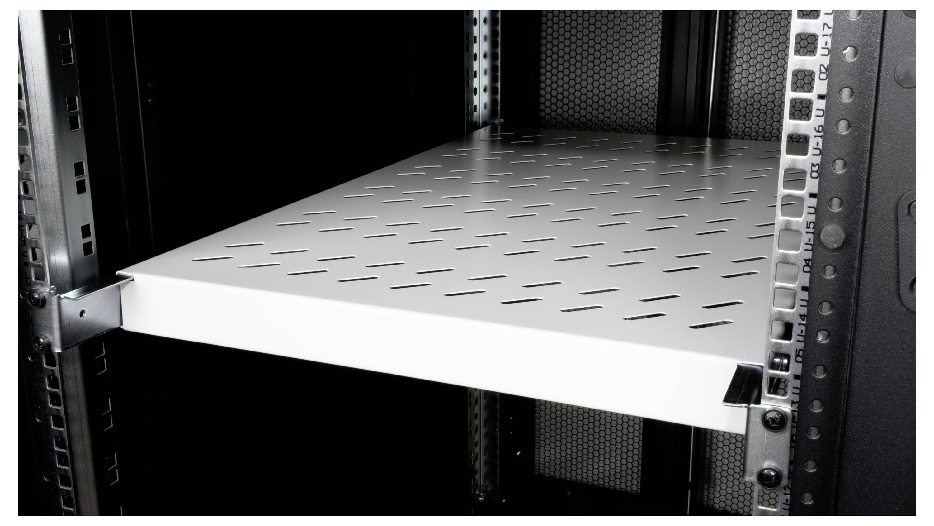 Een geventileerd, metallic rek in een serverrek, geschikt voor het ondersteunen van computer- of netwerkapparatuur.