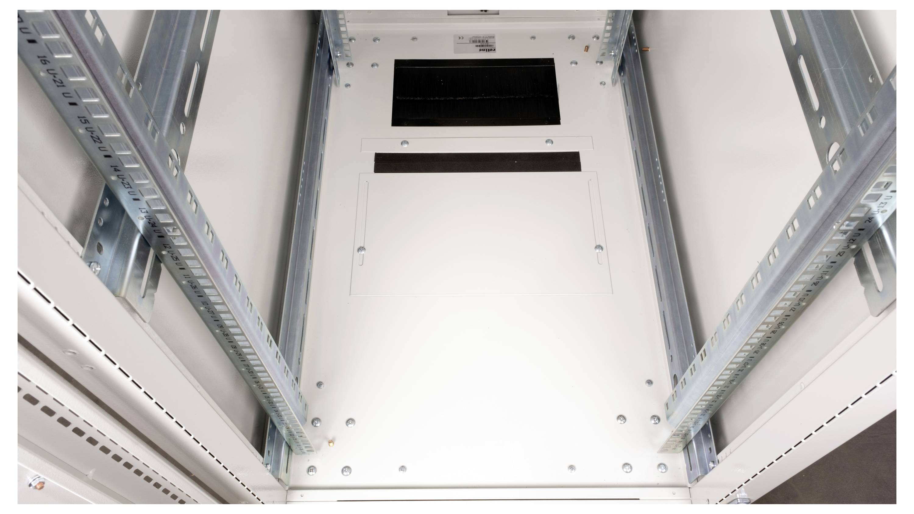 Interieurzicht van een metalen kast met rails, waarschijnlijk gebruikt voor het huisvesten van servers of elektronische apparatuur, met een witte deur aan de achterkant.