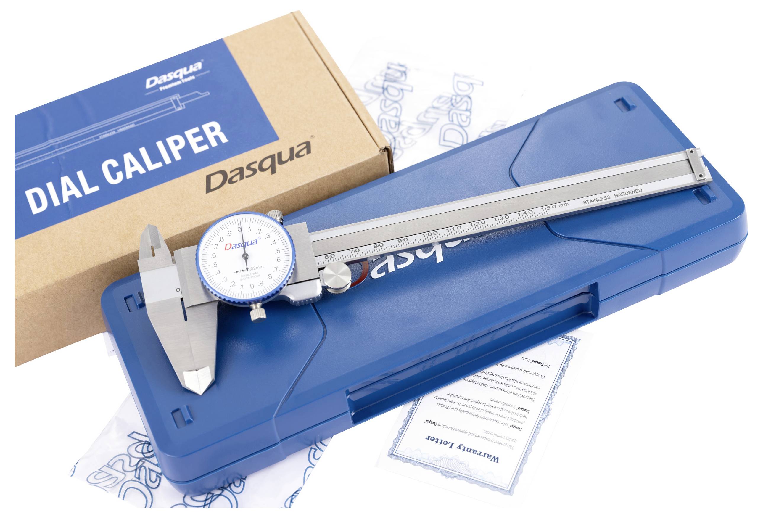 Een schuifmaat met rondschaal ligt op een blauw etui naast een bruine verpakking met het opschrift 'DIAL CALIPER'.