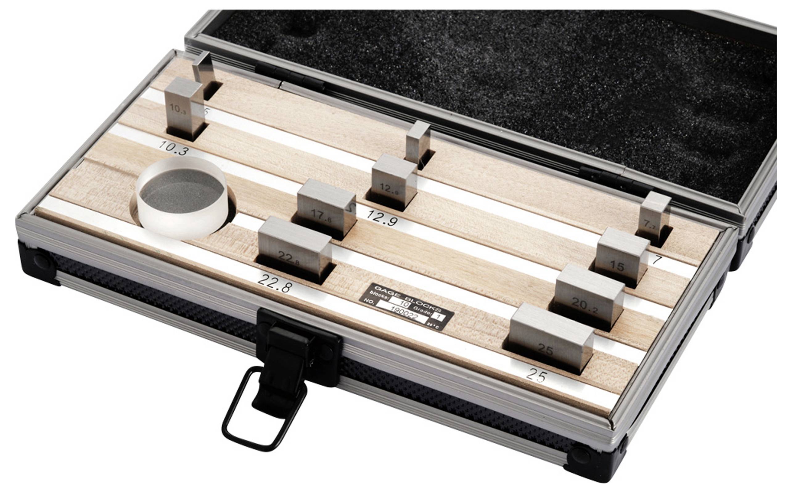 Een open koffer bevat een set metalen blokken van verschillende formaten, genummerd van 8 tot 25, op houten stroken.