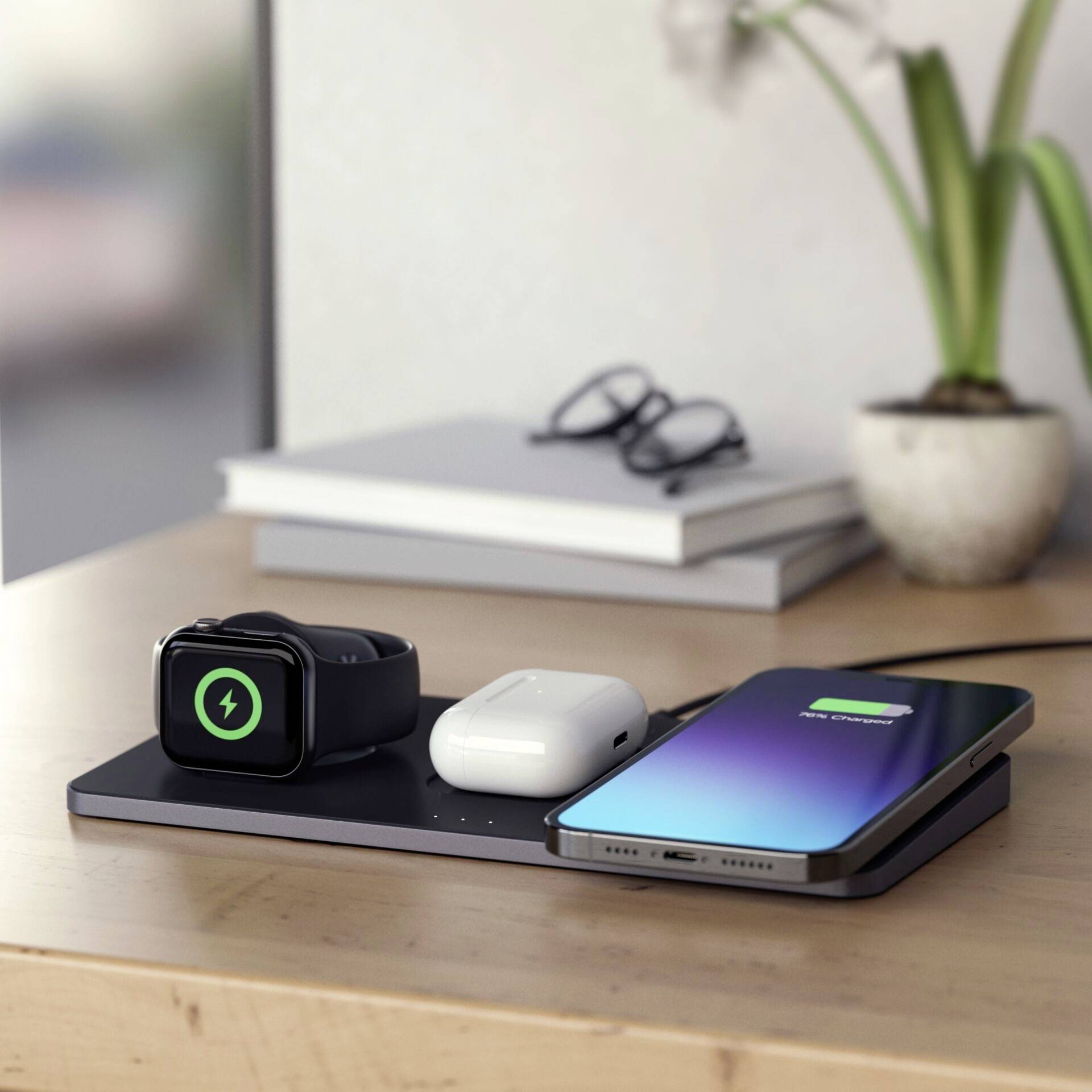 Meerdere apparaten, waaronder een smartphone, een smartwatch en koptelefoons, worden gelijktijdig opgeladen op een draadloos laadstation.