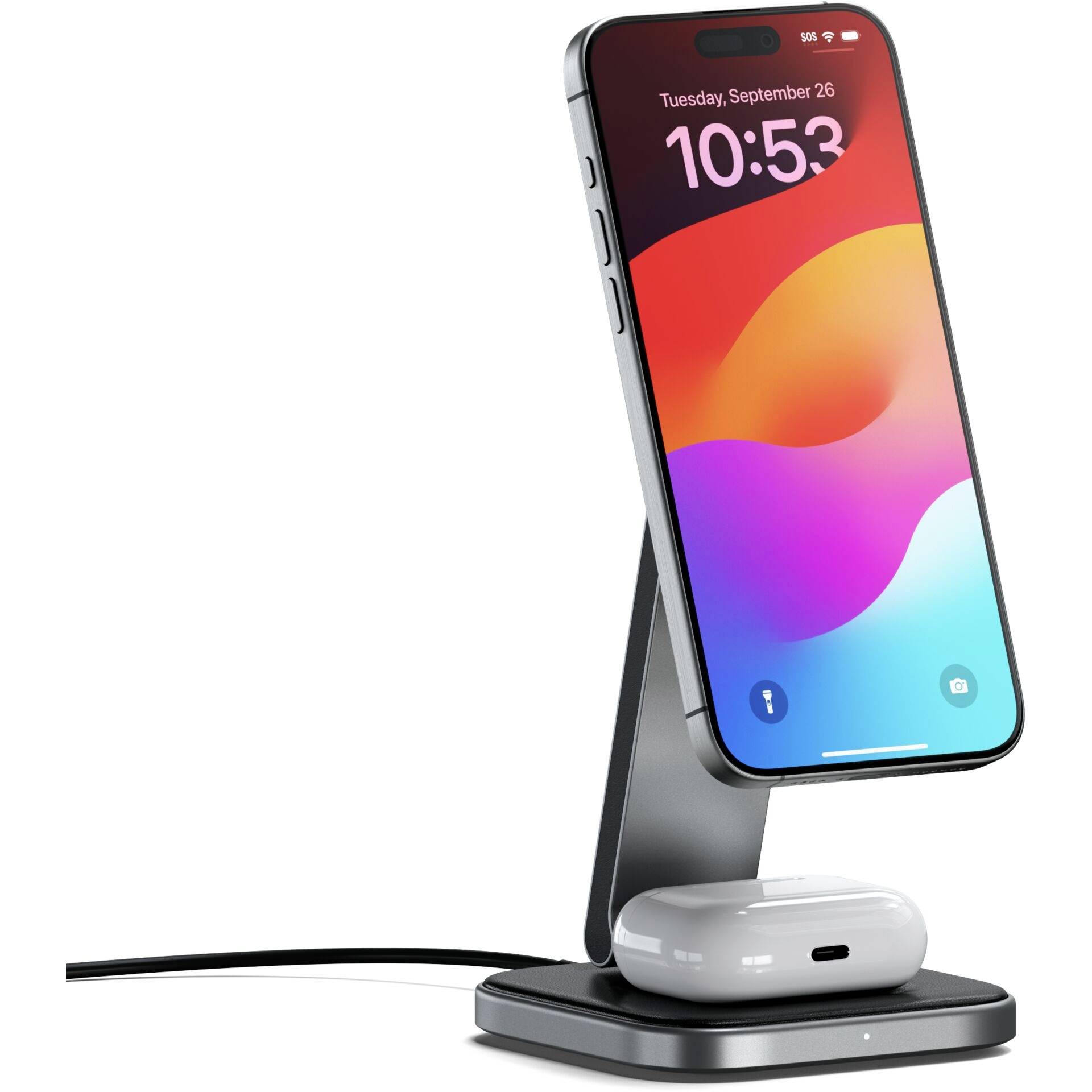 Een smartphone staat rechtop op een draadloos oplaadstation, met daaronder een paar draadloze koptelefoons.