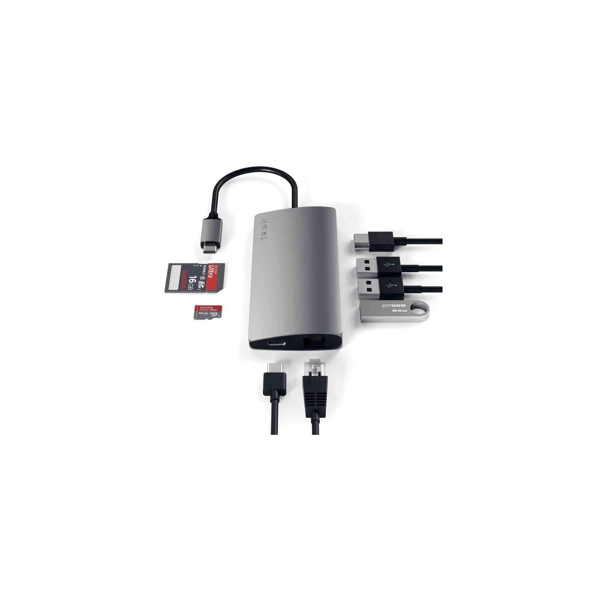 Een zilveren USB-C-hub met meerdere poorten: USB, HDMI, Ethernet en kaartlezer, verbonden met verschillende kabels en geheugenkaarten.