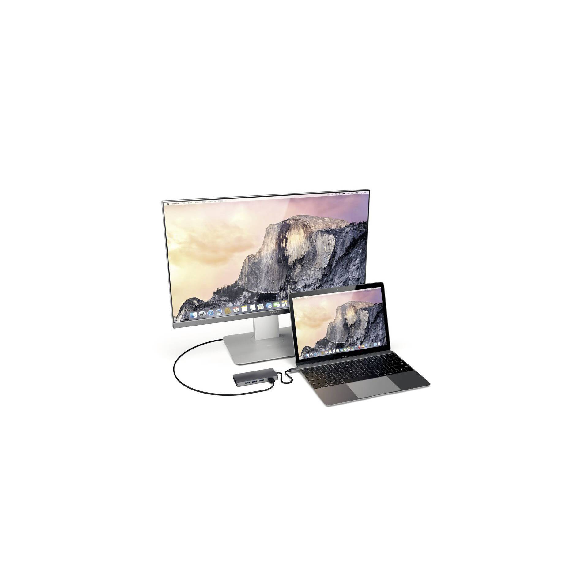 Een monitor en een laptop zijn verbonden en tonen dezelfde schermachtergrond met bergen bij zonsondergang.