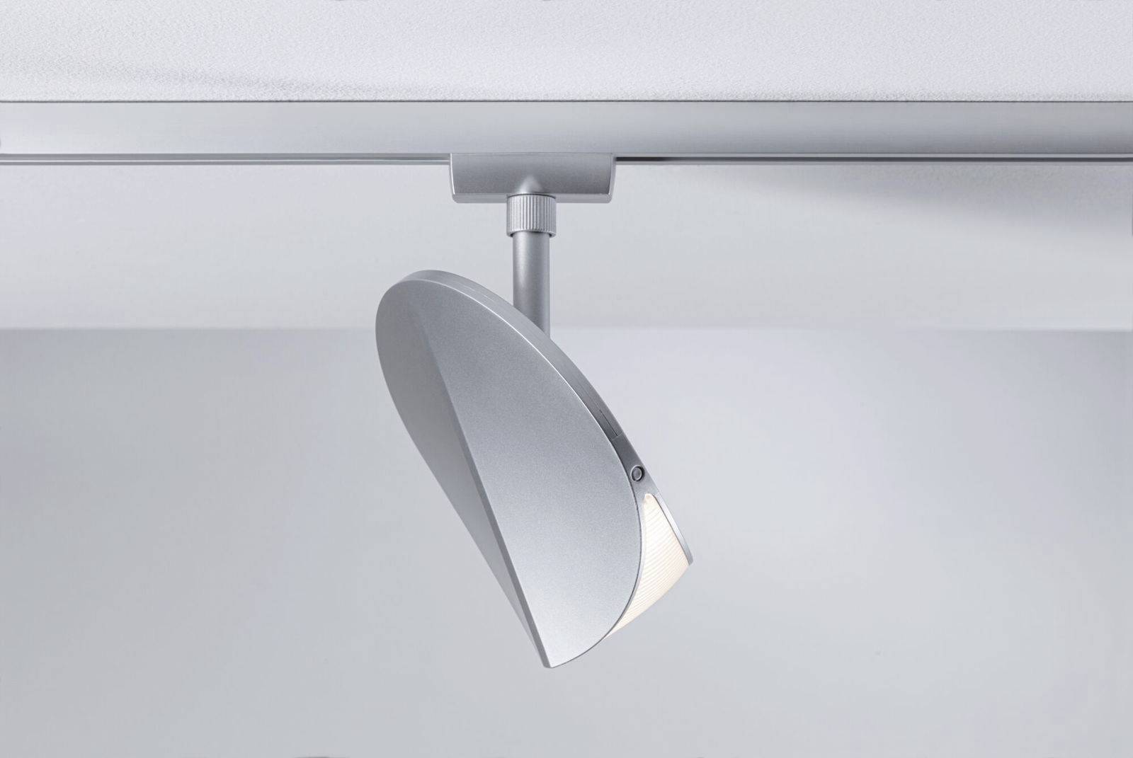 Een moderne LED-plafondspot in zilver, gemonteerd op een rail, geschikt voor gerichte verlichting van binnenruimtes.