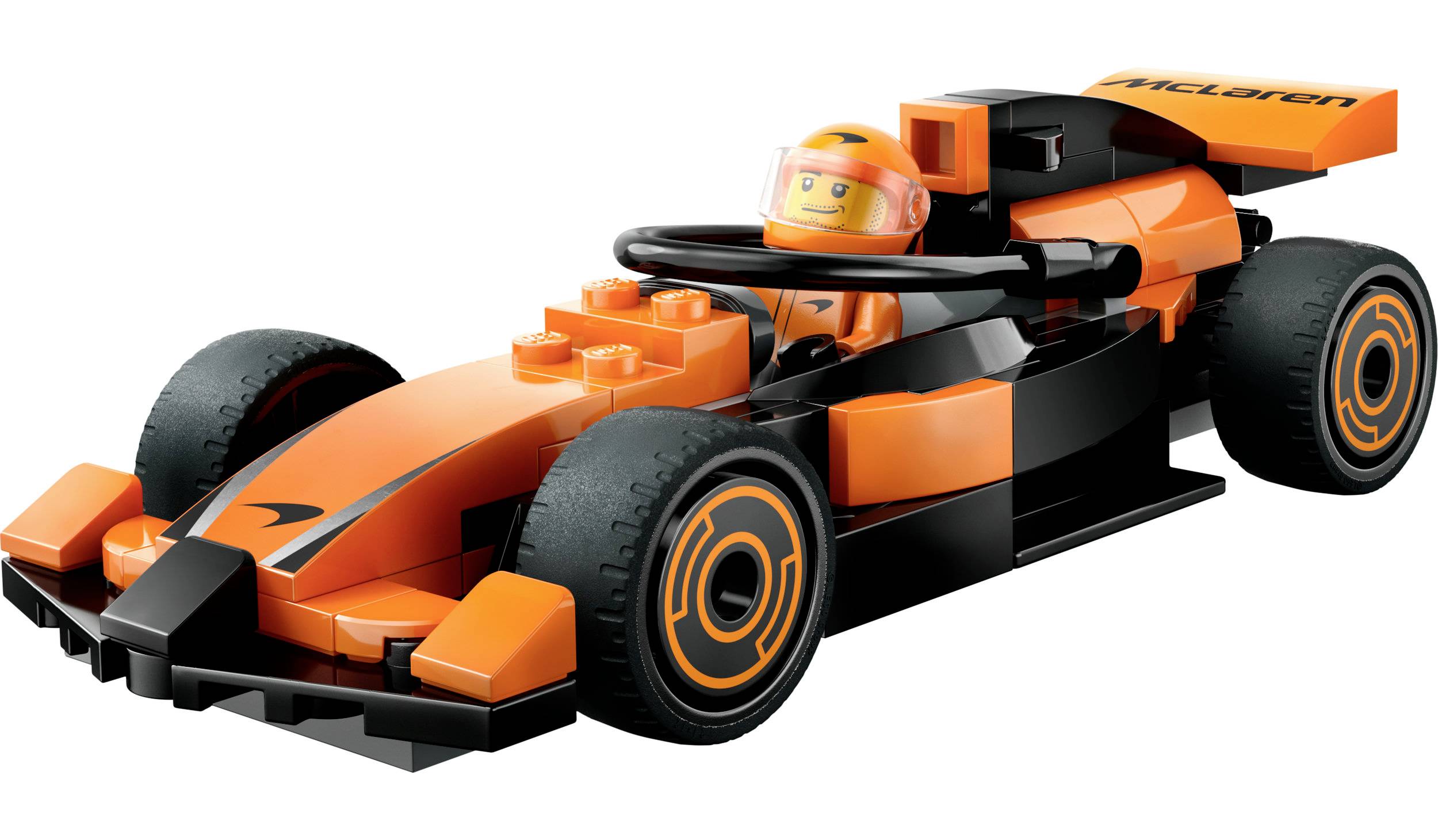 Een kleine, oranje speelgoed-raceauto gemaakt van bouwstenen met een bestuurdersfiguur in de cockpit.