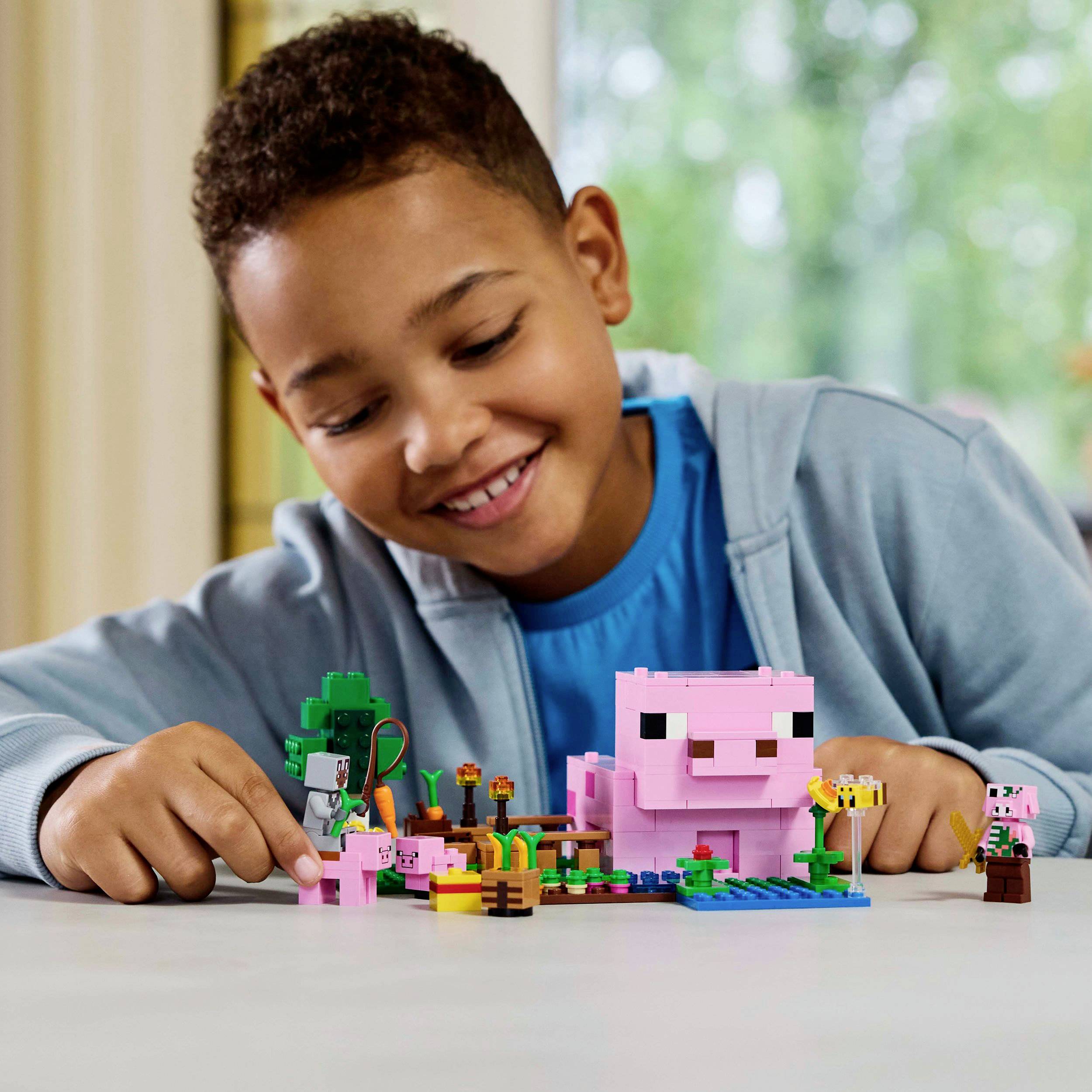 Een kind speelt met een LEGO-set dat een kleurrijk landelijk tafereel met dieren en planten voorstelt. Het kind ziet er blij en geconcentreerd uit.