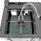 3D-printer in actie, maakt een object op zijn platform. De printkoppen bewegen zich nauwkeurig over een vierkant oppervlak.