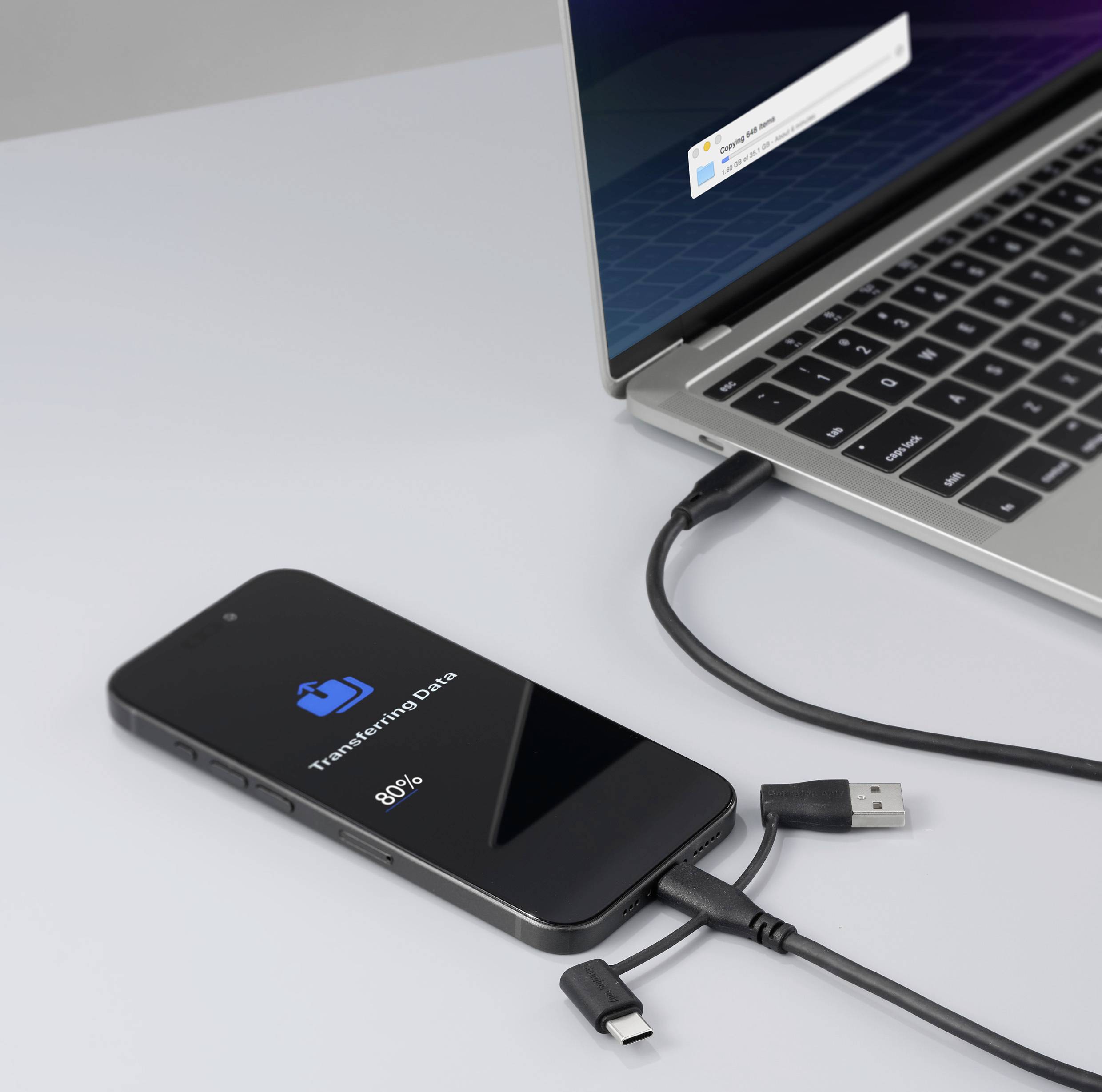 Smartphone dat is aangesloten op laptop toont 'Gegevensoverdracht 85%'. Gegevensoverdracht van het ene apparaat naar het andere.