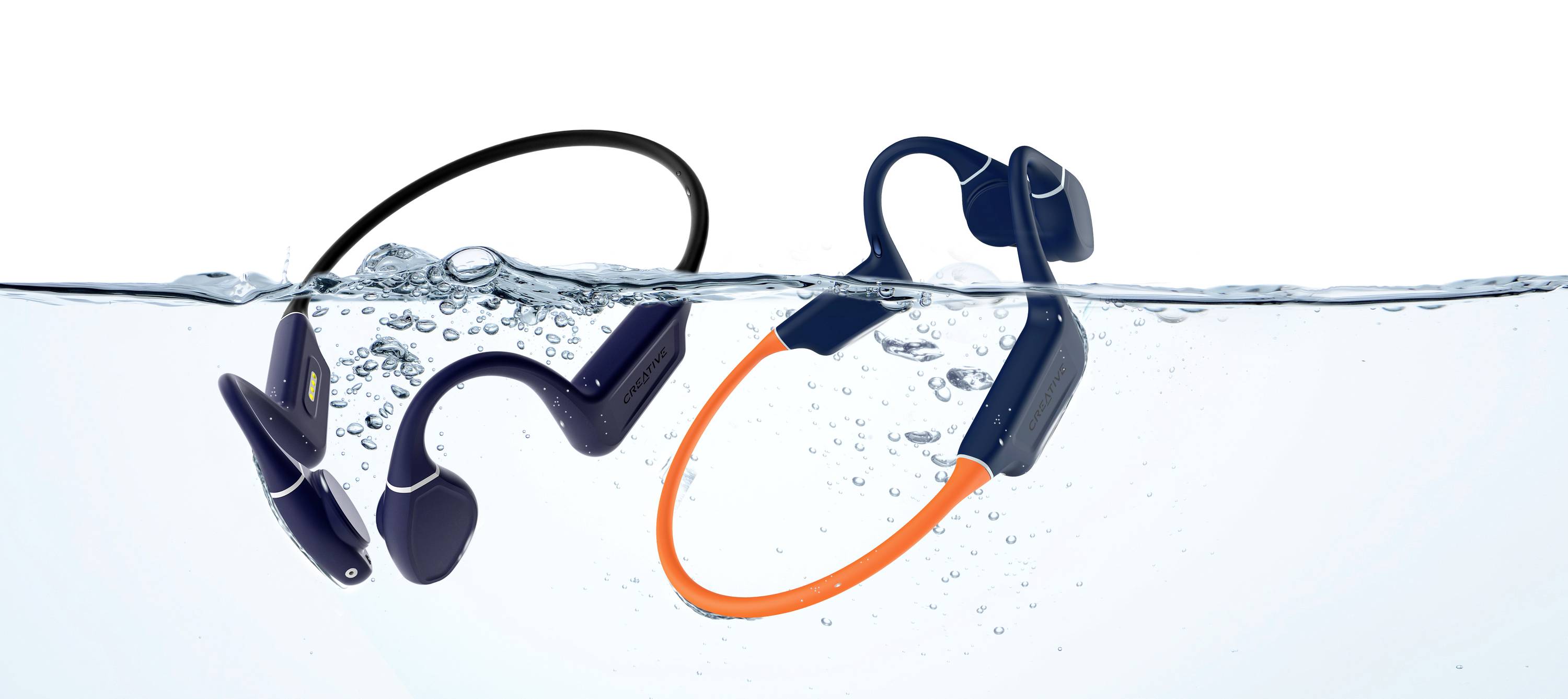 Twee waterdichte koptelefoons in zwart en blauw/oranje zweven licht onder water, wat hun waterbestendigheid aantoont.