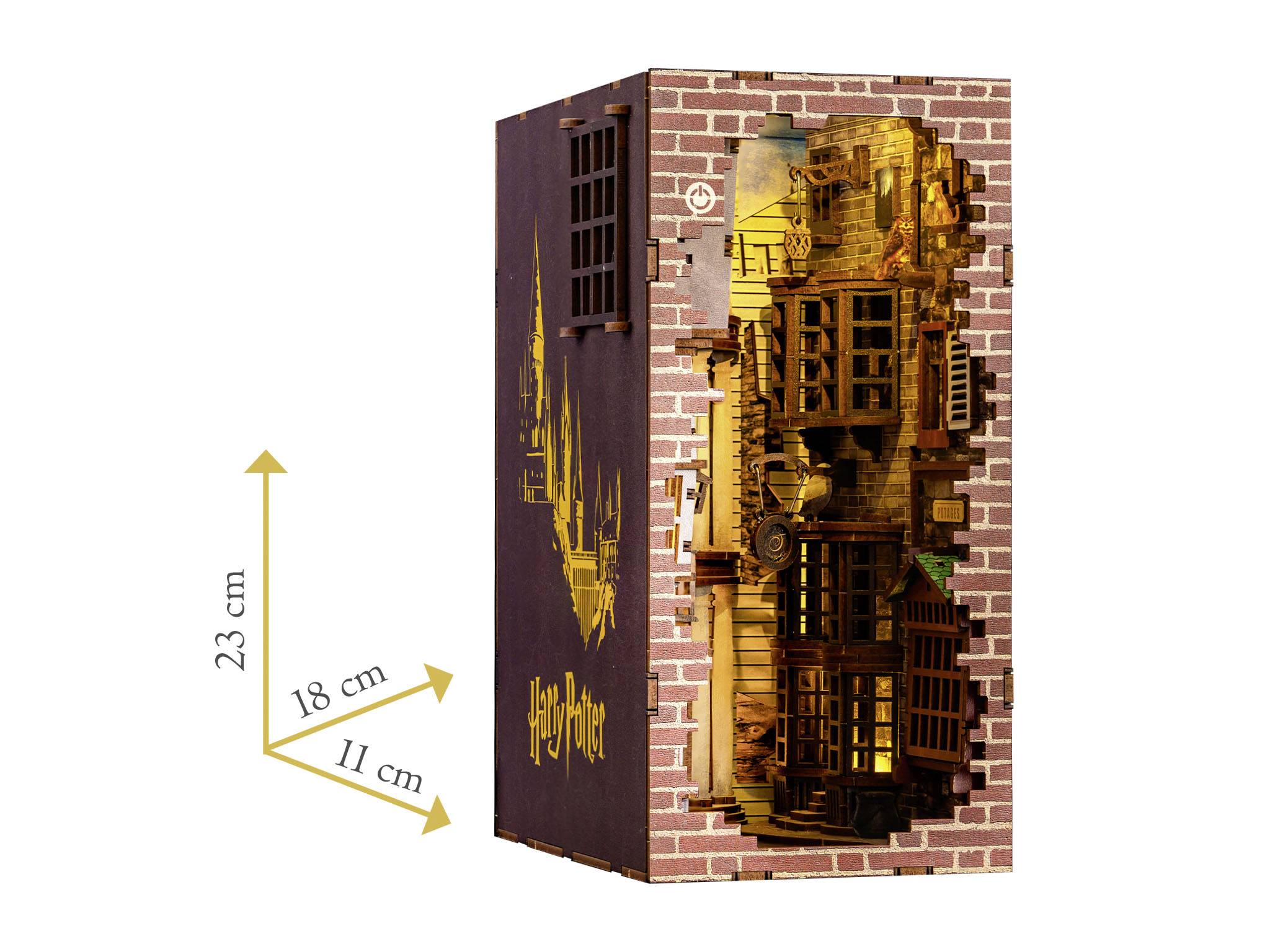 Een gedetailleerd model met 'Harry Potter'-ontwerp toont een tovenaarsstraat achter een bakstenen muur. Afmetingen: 23 cm hoog, 18 cm diep, 11 cm breed.