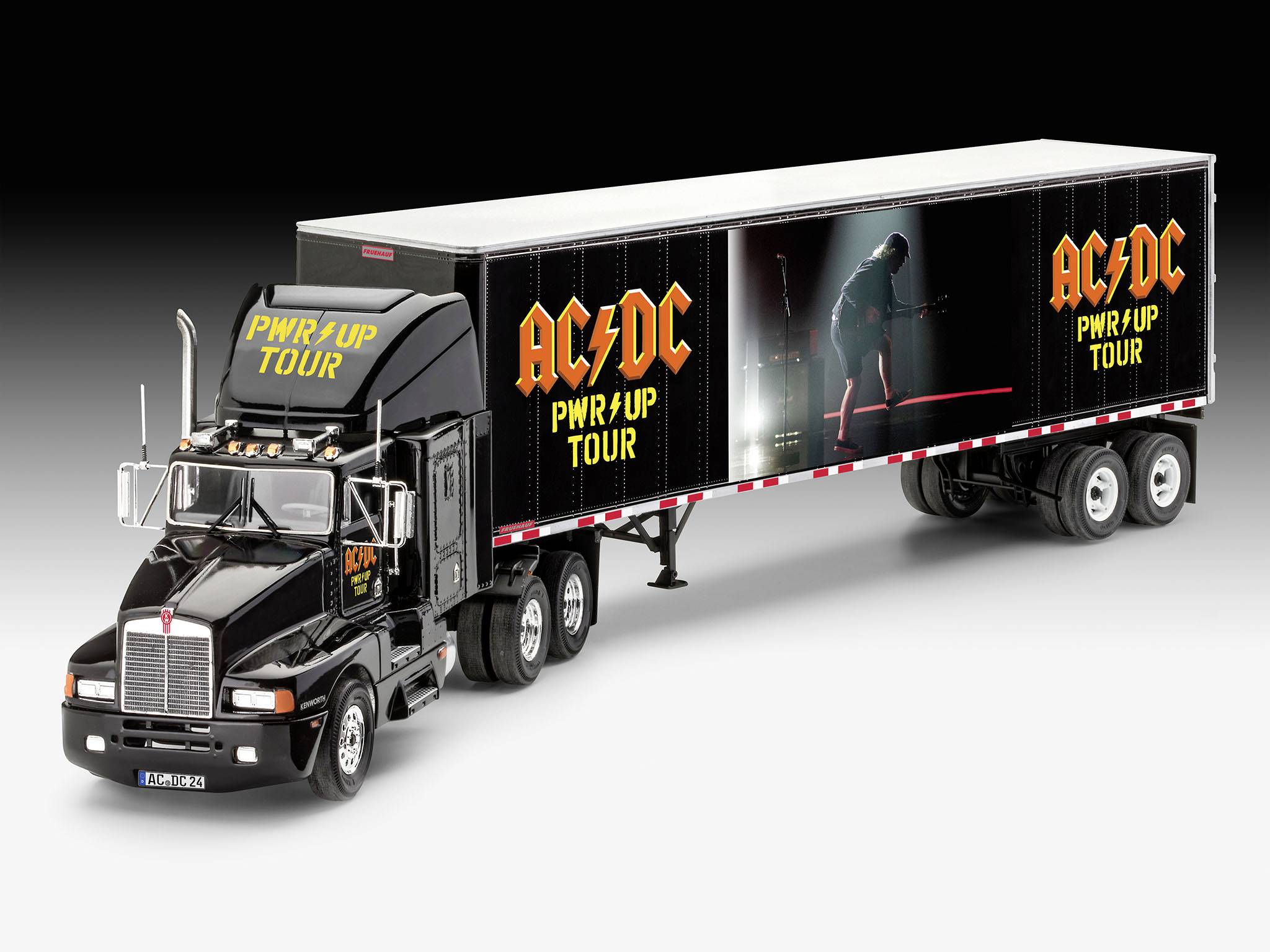 Een zwarte vrachtwagen met aanhanger, met daarop het logo van de band AC/DC en de tekst 'PWR/UP Tour', toont een podiumontwerp met een gitarist.