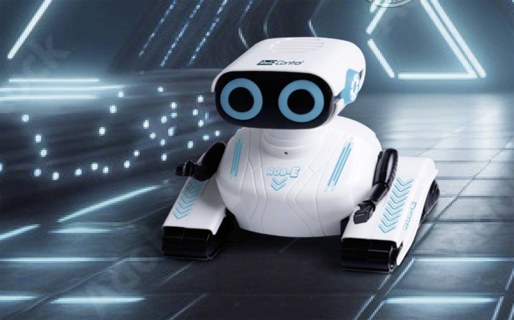 Een kleine, wit-blauwe robot met twee opvallende ronde ogen staat in een futuristische omgeving met neonblauwe verlichting.
