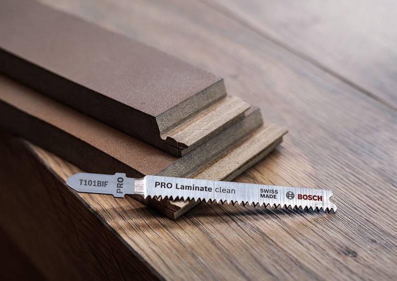 Een Bosch zaagblad ligt op houten platen. Op het blad staat 'PRO Laminate clean'. Het werd vervaardigd in Zwitserland.