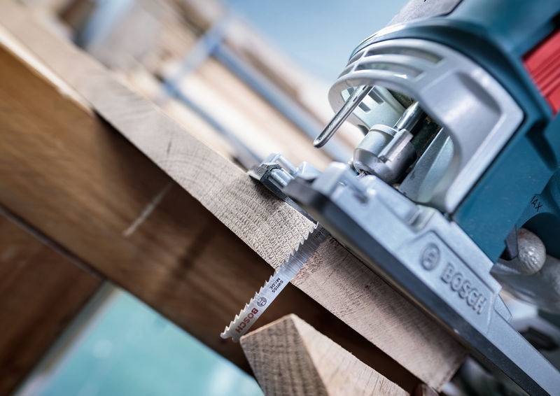 Een cirkelzaag zaagt door een stuk hout. De machine is van dichtbij te zien terwijl hij nauwkeurig zijn werk doet.