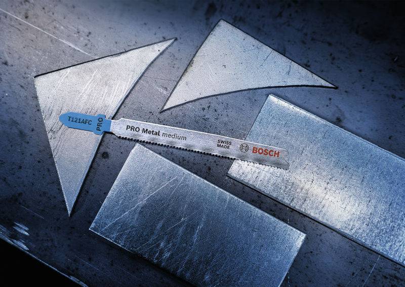 Het metaalzaagblad 'PRO Metal medium' van Bosch ligt op een donkere metalen tafel, omringd door afgesneden metaalstukken.
