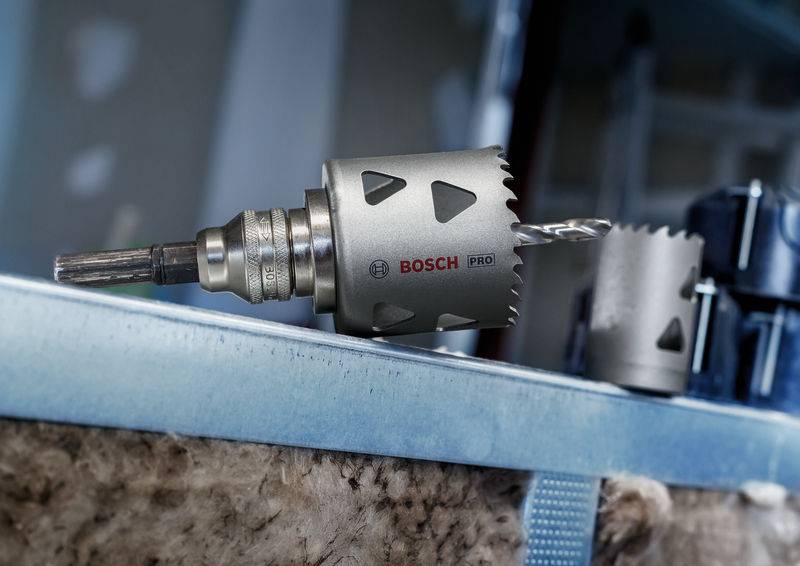 Een Bosch gatenzaagboor, gemonteerd op een metalen oppervlak, toont zijn snijtanden en een boor in een bouwomgeving.