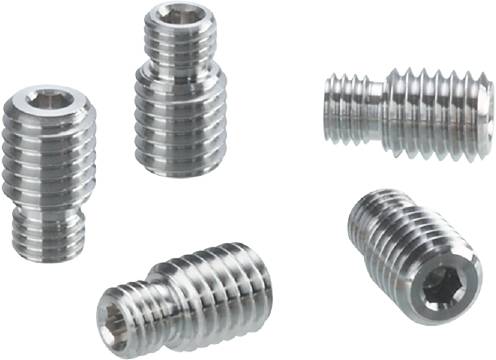 Vijf zilveren metalen schroeven met groeven op een witte achtergrond, op verschillende manieren gerangschikt.