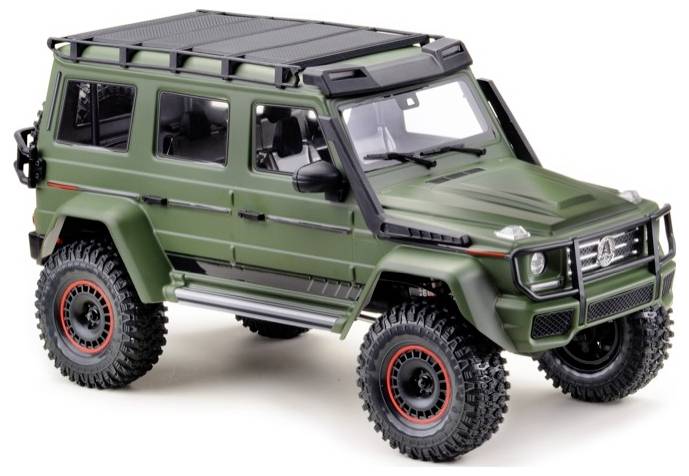 Groene terreinwagen met robuuste banden en dakdragers, gefotografeerd van schuin voren.