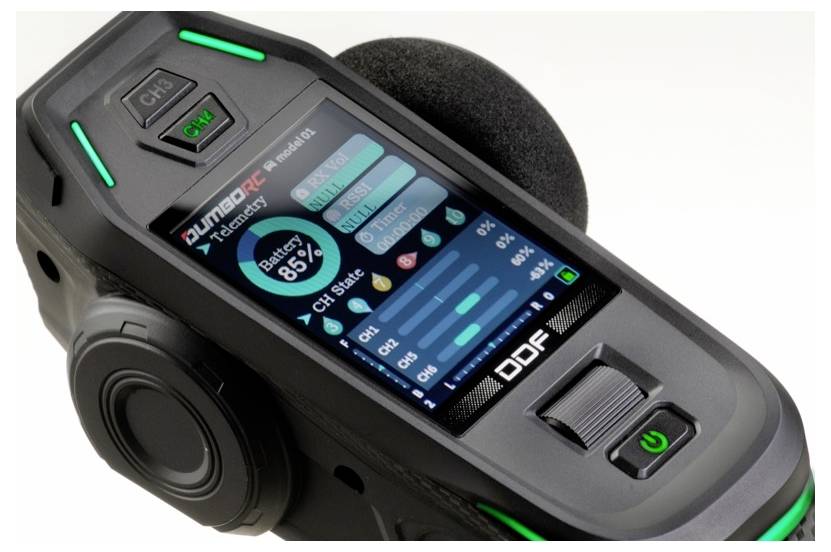 Een zwarte elektronische controller met groen oplichtende accenten, een display dat informatie toont zoals batterijstatus en kanaalinstellingen.