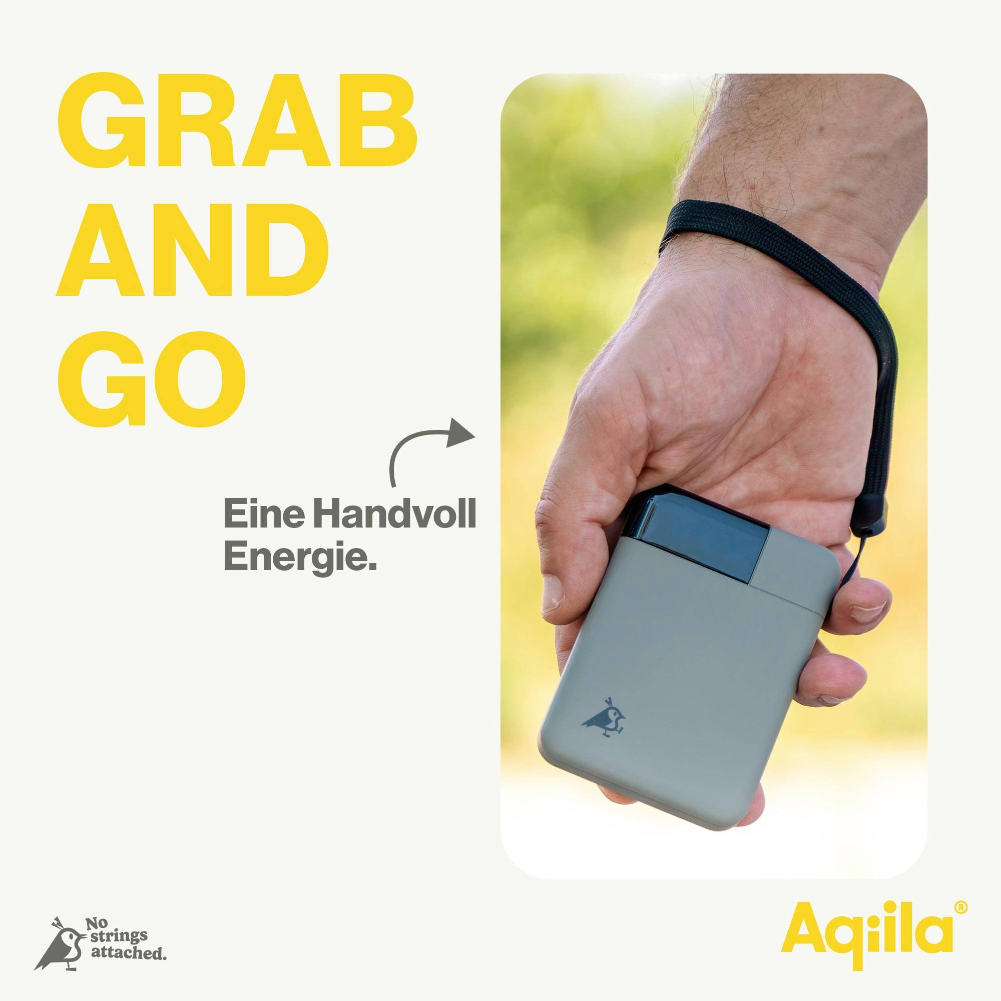 Een hand houdt een compacte, draagbare powerbank met lus vast. Tekst: 'Een handvol energie'. Merklogo en slogan linksonder.