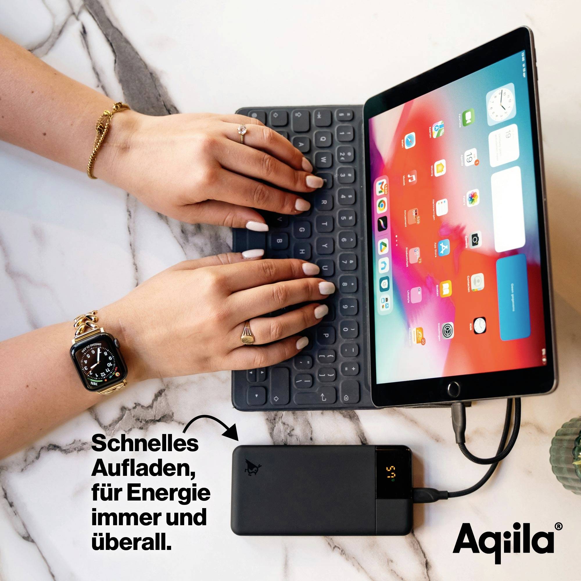 Tablet met toetsenbord, opgeladen door een powerbank. Twee handen typen op het toetsenbord. Tekst: 'Snel opladen, energie altijd en overal beschikbaar.'
