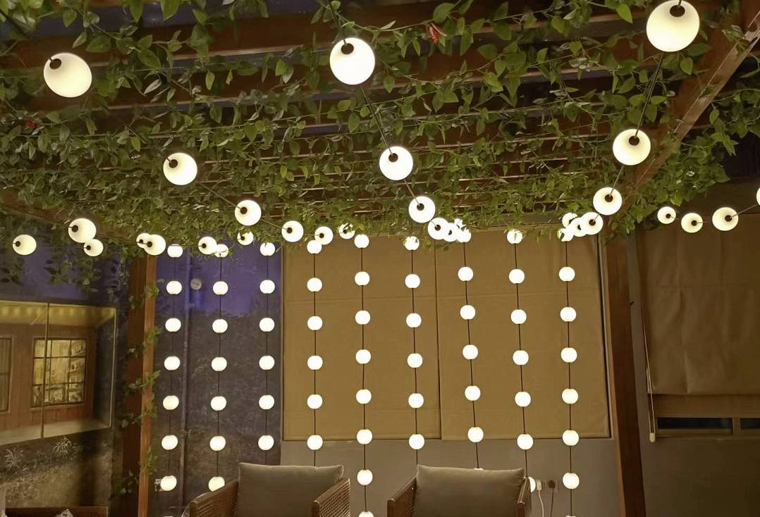 Een gezellig terras met hangende lichtslingers en planten die een warme en uitnodigende sfeer creëren.