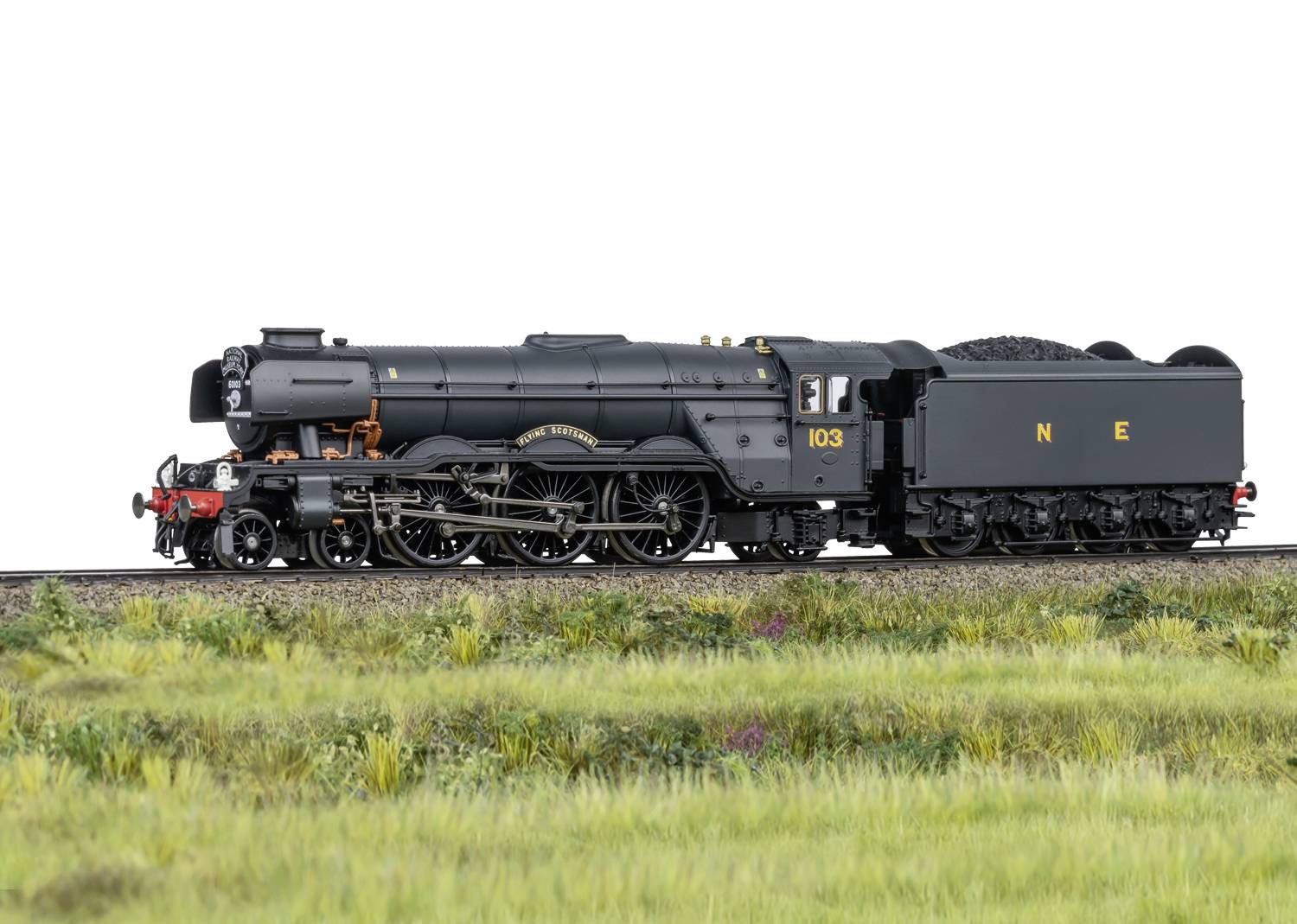 Een modeltreintje van een historische stoomlocomotief rijdt over een spoorsectie. De locomotief is zwart met gouden details.