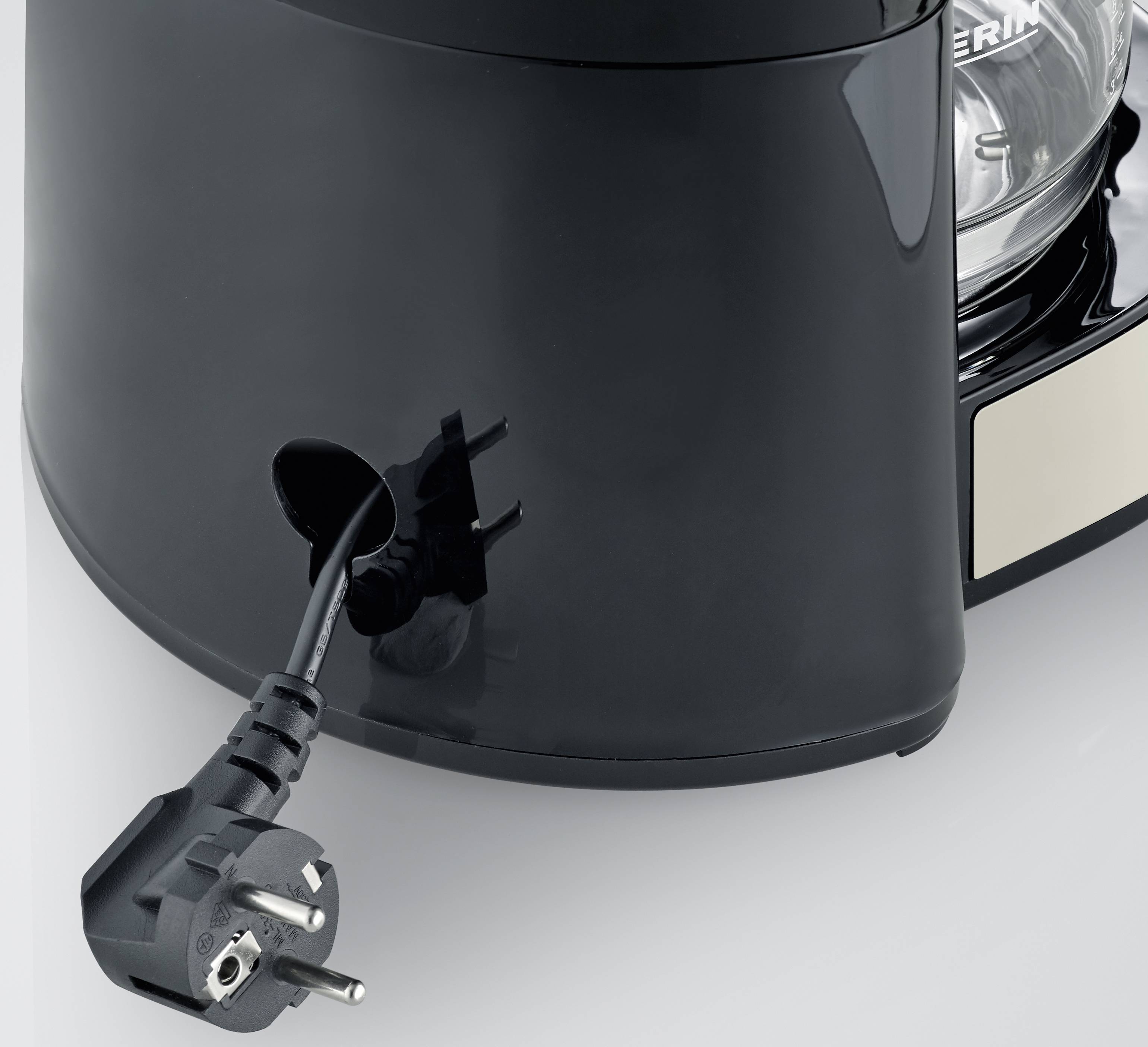 Een zwarte koffiemachine is van opzij te zien. Een stroomkabel wordt aan de achterkant van de machine aangesloten.