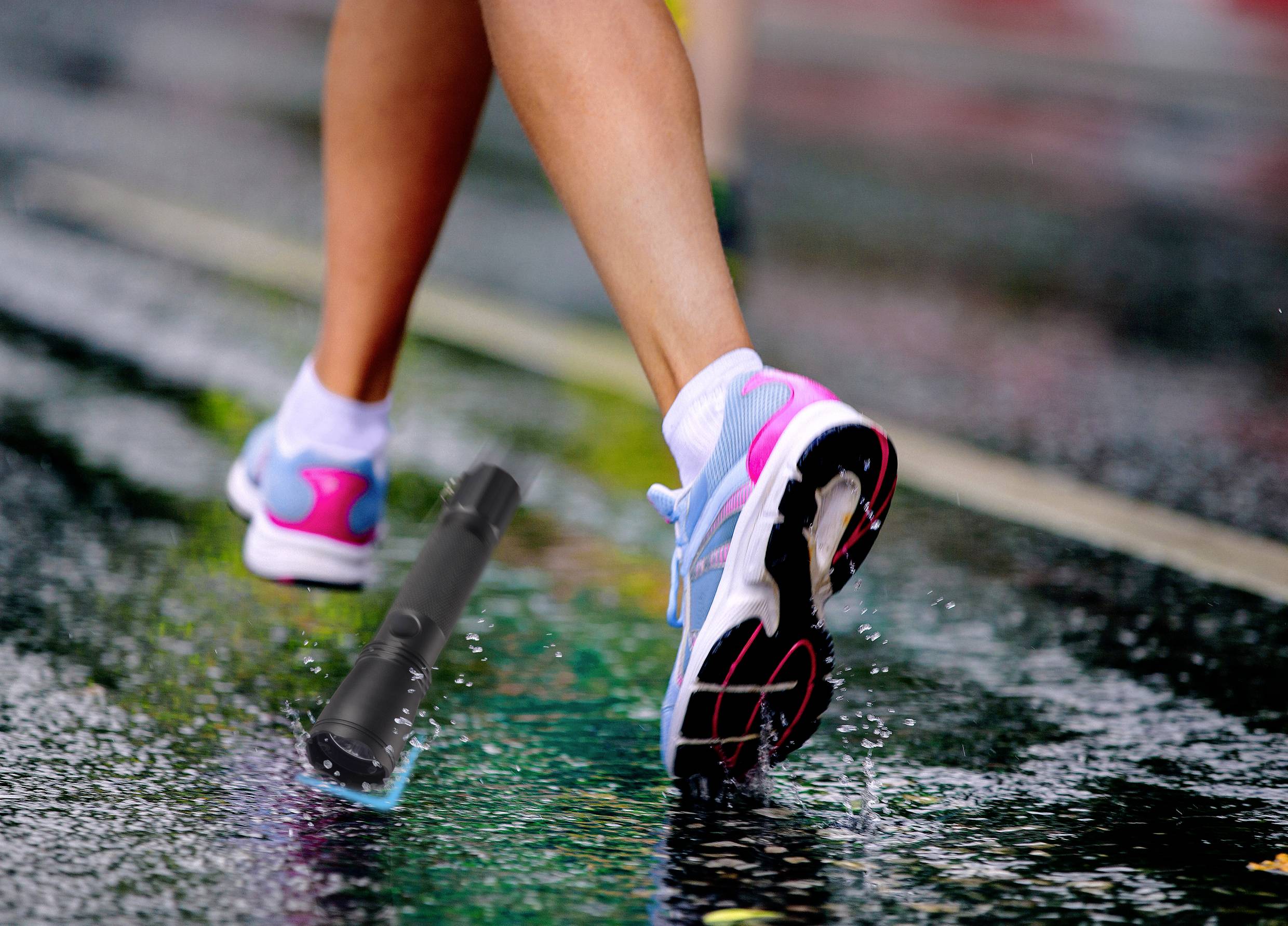 Hardloopbenen in sportschoenen onderweg op een regenachtige weg. Een kleine tak ligt op de straat.
