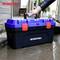 Een persoon tilt voorzichtig een blauwe en zwarte gereedschapskist met het opschrift 'WORKPRO' uit een plas water.